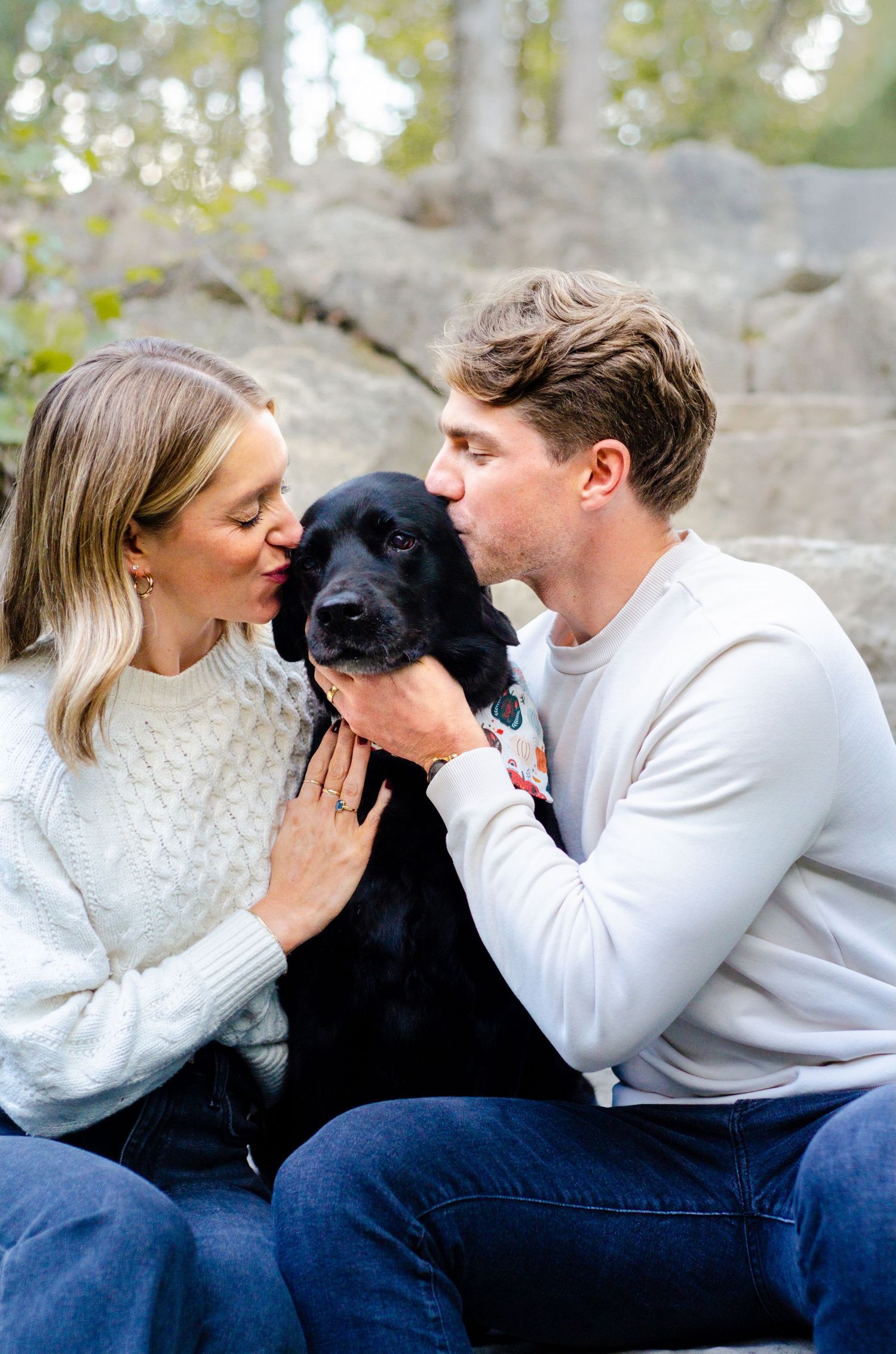 A couple shares tender moments with their black dog while sitting outdoors. Pet photos by KM Conceptions Photography in Columbus, OH.