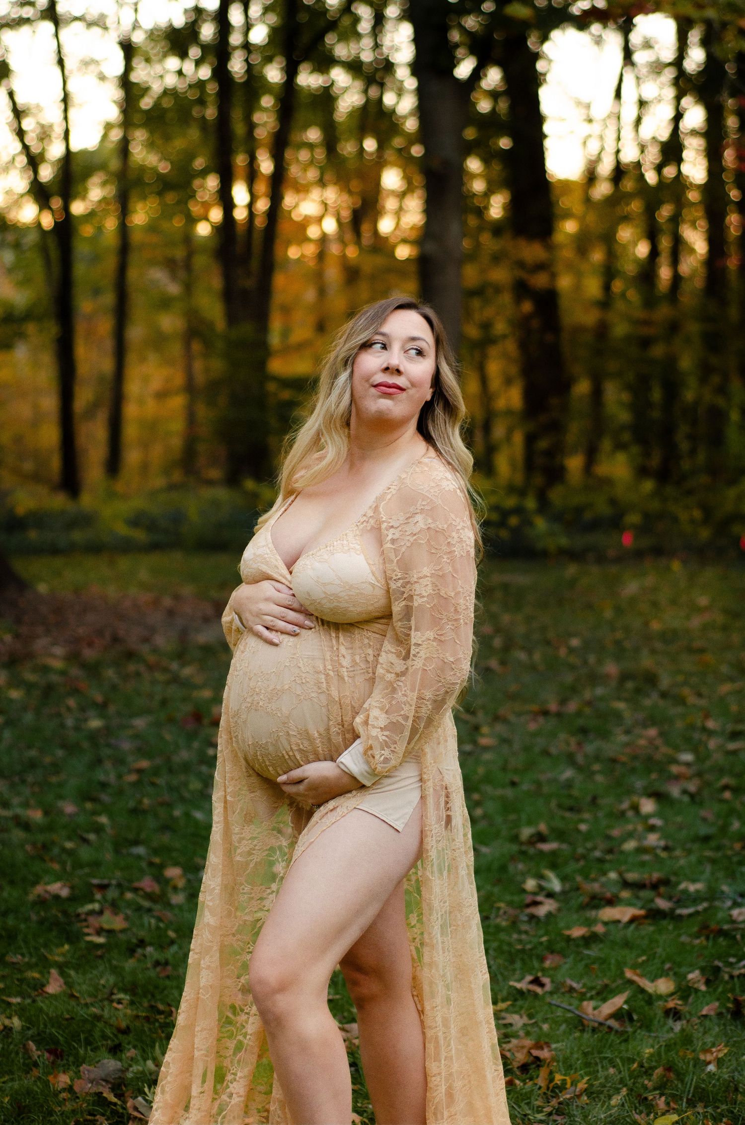 Maternity photo in a peach lace gown against autumn forest backdrop. Maternity photos by KM Conceptions Photography in Columbus, OH.