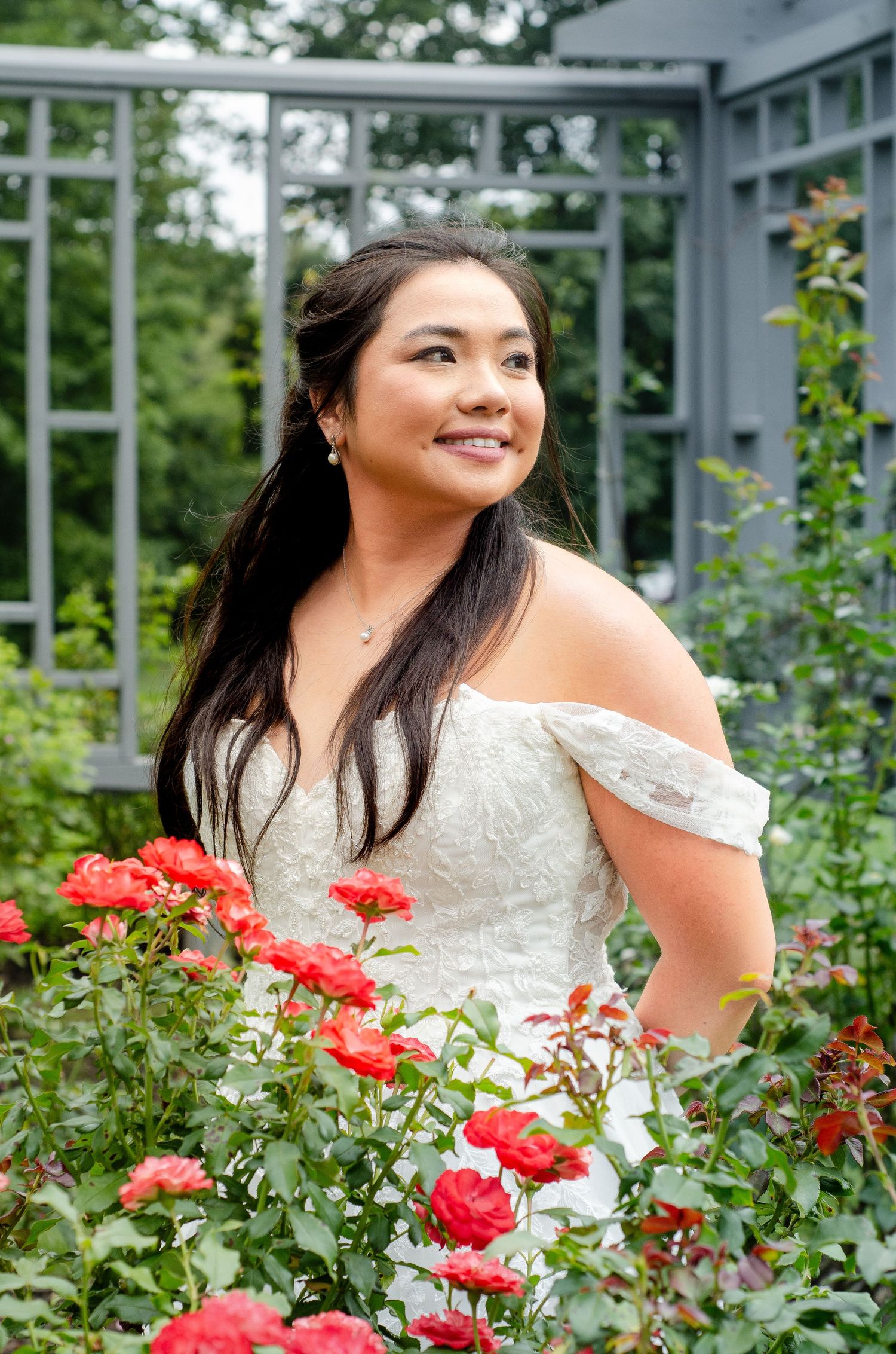 Beautiful bride in white dress poses with vibrant red roses. Wedding photos by KM Conceptions Photography in Columbus