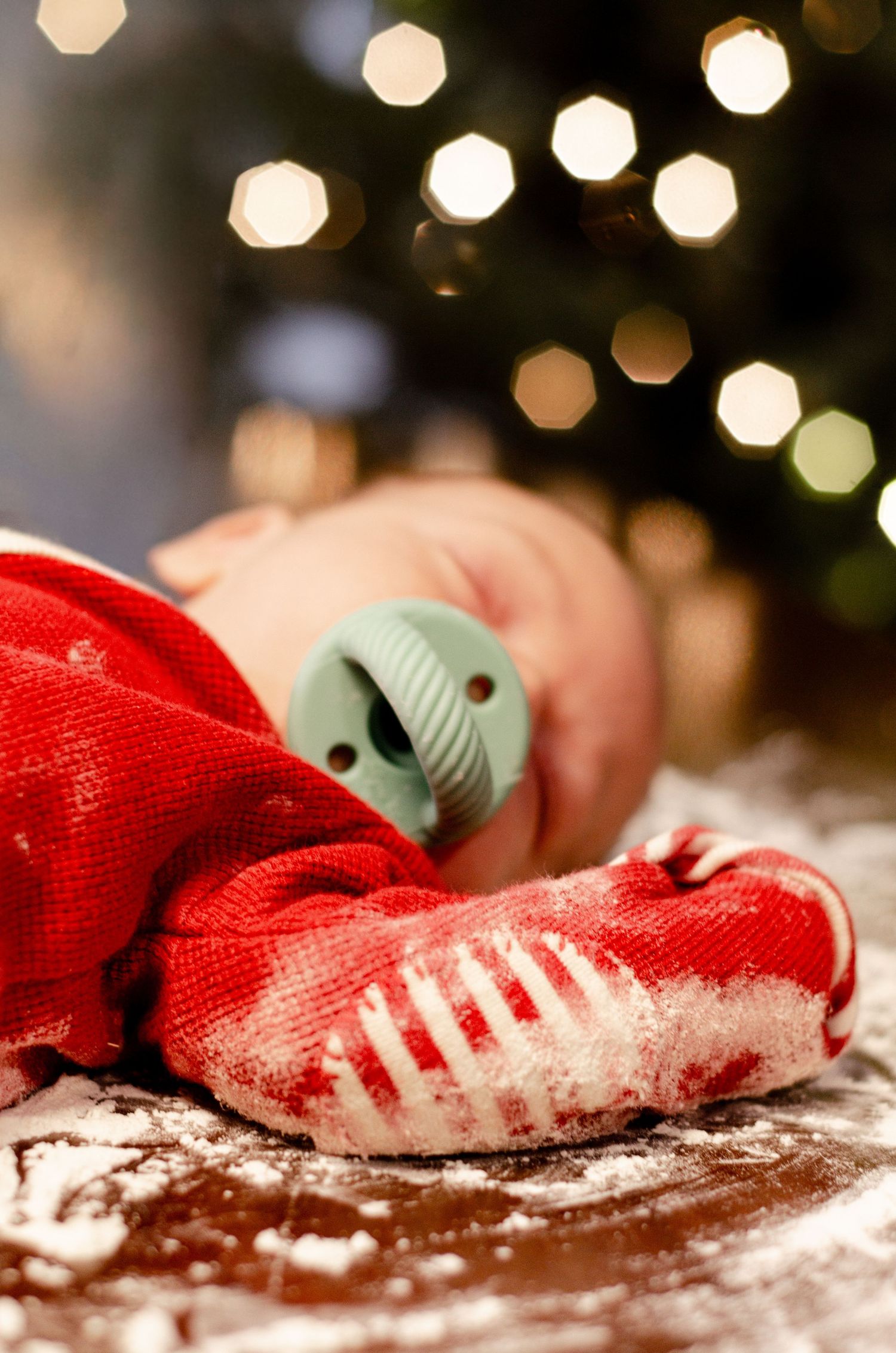 Red and white striped socks with bokeh lights in background on flour-dusted surface. Newborn photography in Columbus, OH
