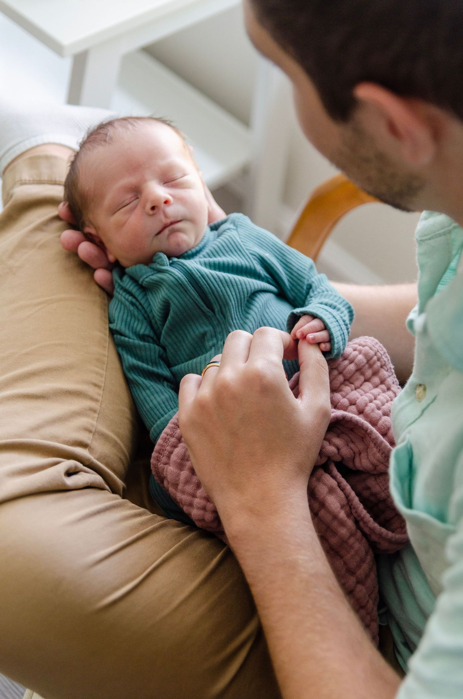 Intimate newborn photography sequence showing gentle moments with baby in teal clothing. Newborn photos by KM Conceptions Photography.