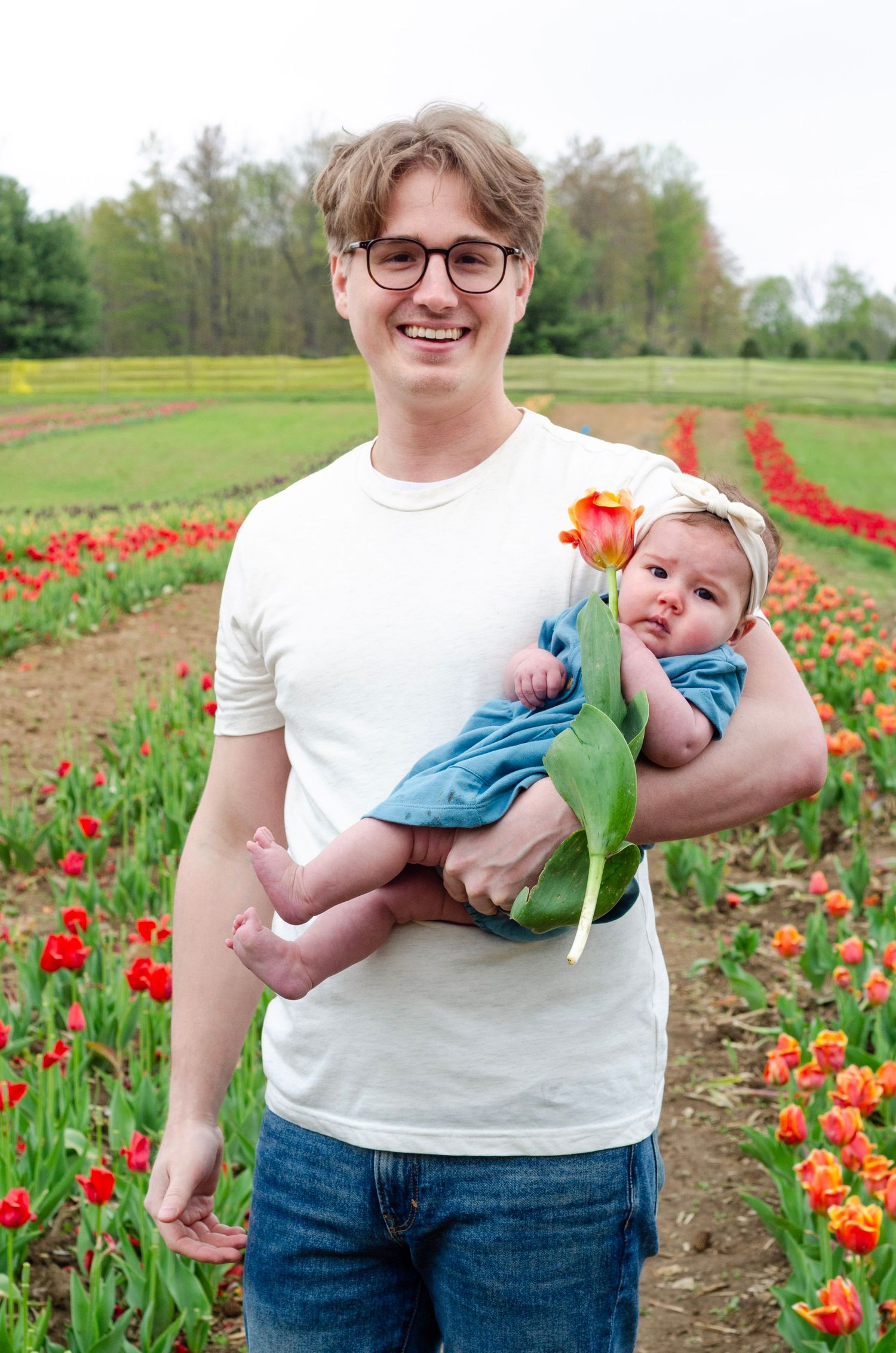 Colorful tulip fields with rows of red and orange blooms stretching into the distance.