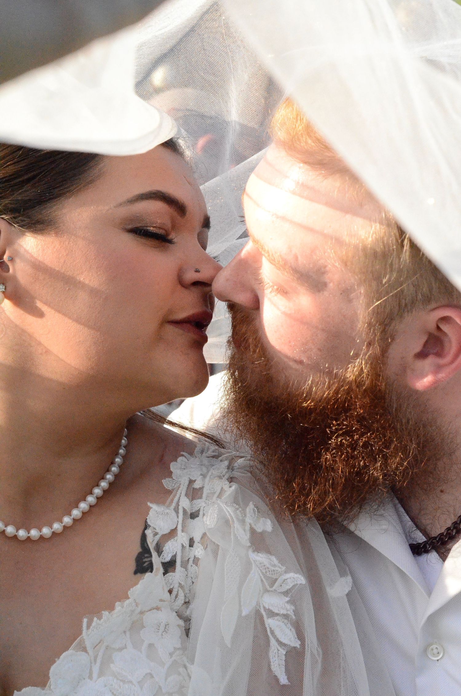 Intimate wedding portrait showing a gentle kiss under a flowing white veil. Wedding photos by KM Conceptions Photography in Columbus, OH.