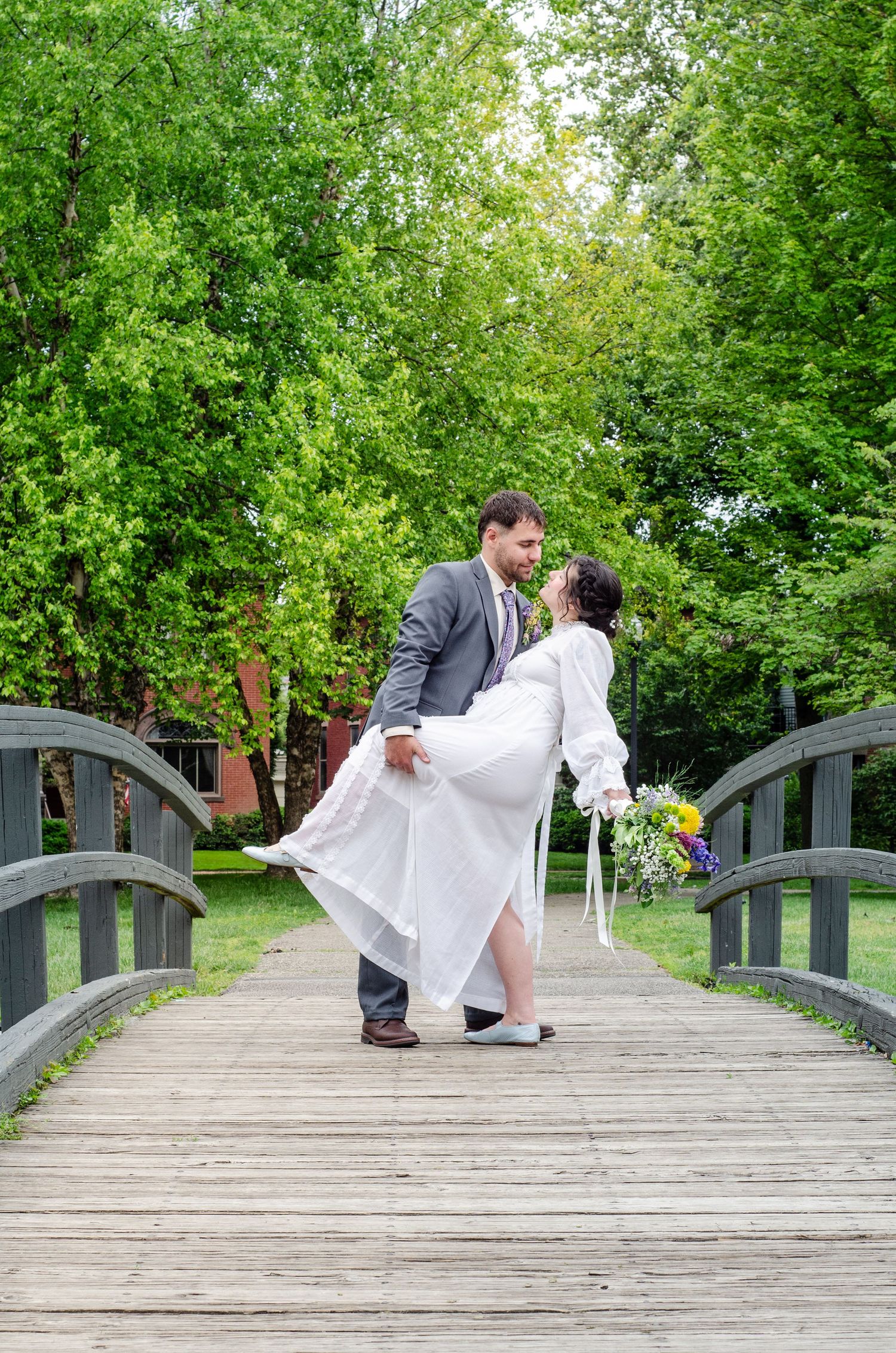 Romantic wedding photo sequence on a wooden bridge surrounded by lush green trees. Wedding photos by KM Conceptions Photography in Columbus,