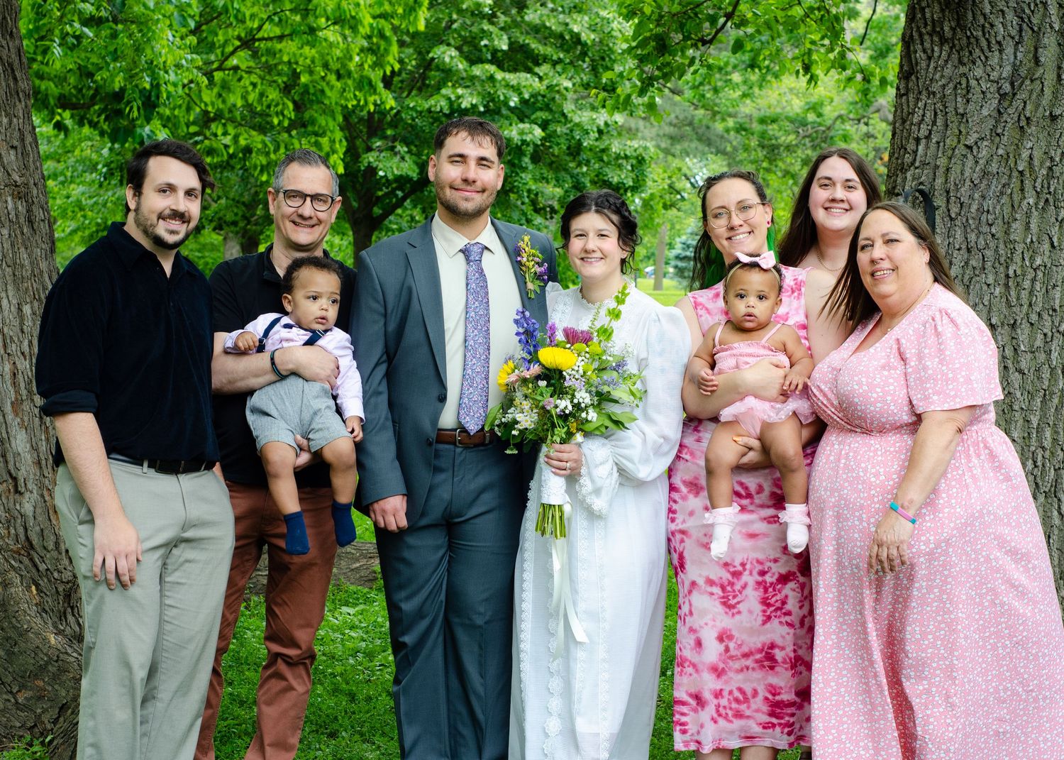 Wedding party group photo outdoors with pink dresses and floral bouquets. Wedding photos by KM Conceptions Photography in Columbus, OH.