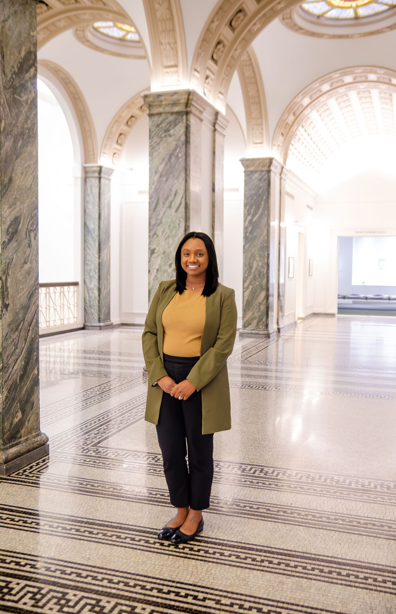 Architectural photoshoot in a grand marble corridor with decorative floor patterns and arched ceilings. Photos by KM Conceptions Photography