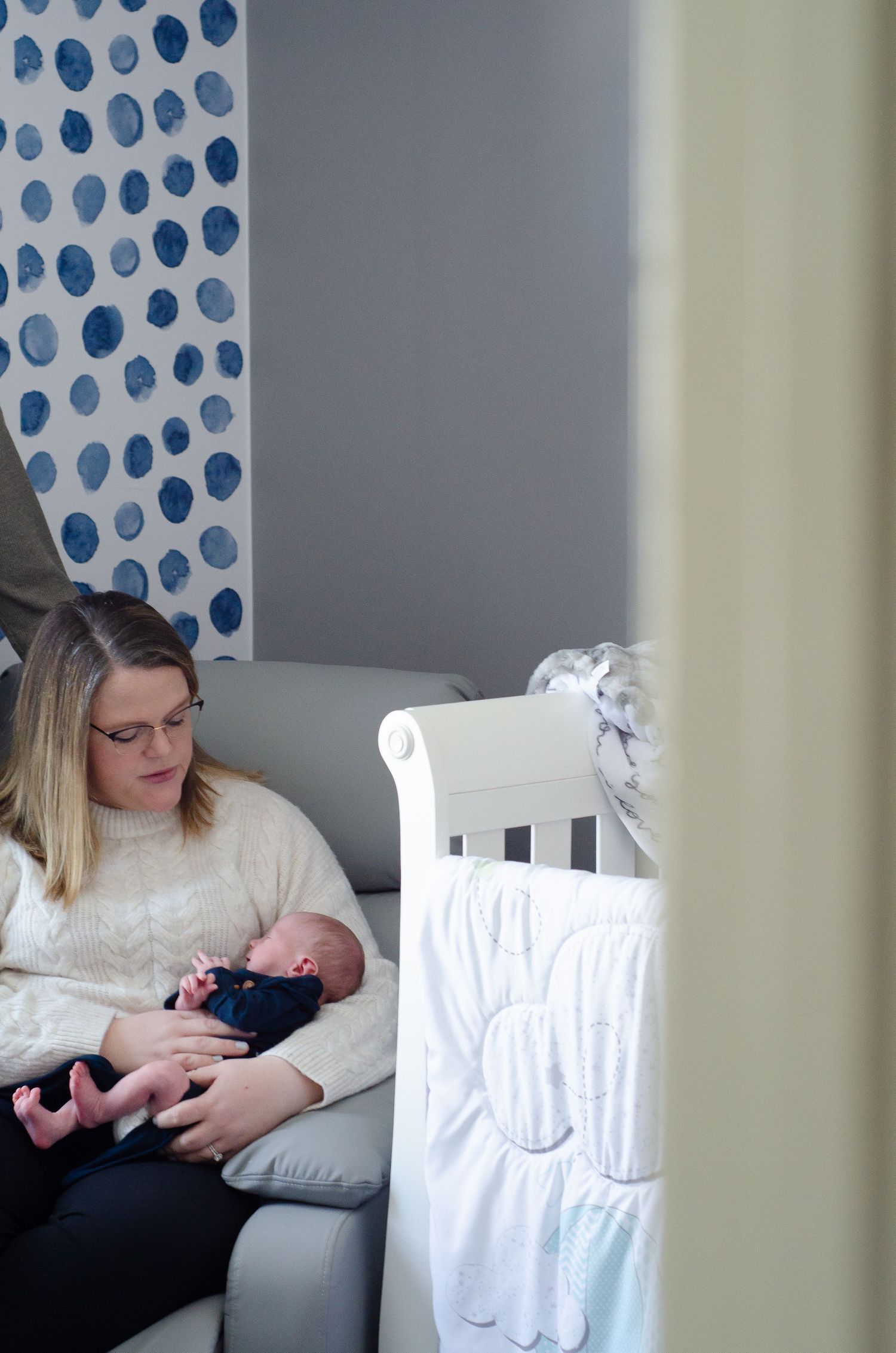 Series of photos showing quiet moments with a newborn in a polka dot nursery setting. Newborn photos by KM Conceptions Photography