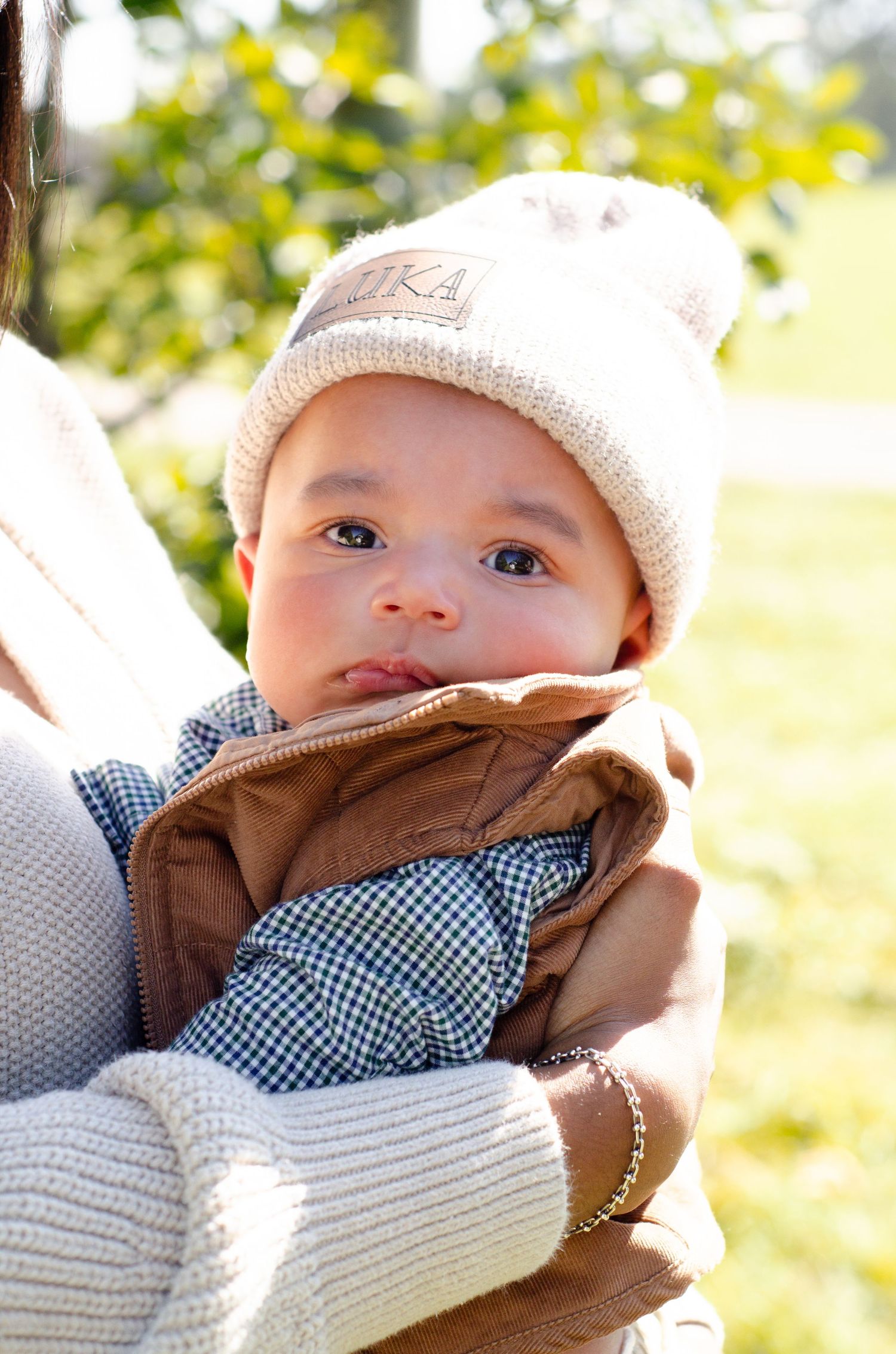 Close up of a baby in a knit hat and blue checkered shirt on a sunny day. Family photos by KM Conceptions Photography in Columbus, OH.