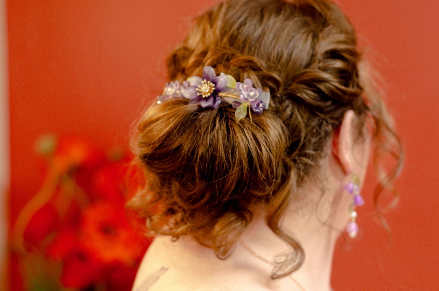 Elegant wedding hairstyle adorned with purple flowers against a red background. Wedding photos by KM Conceptions Photography in Columbus, OH