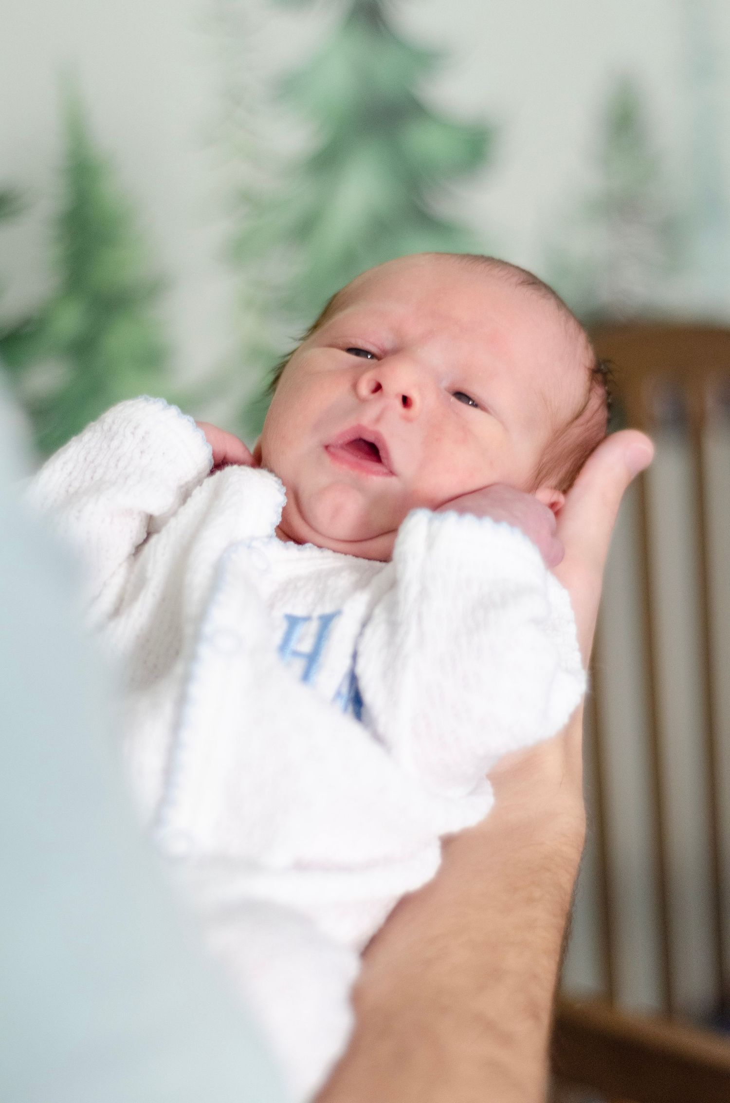 Series of close-up shots showing a newborn baby in white clothing against a light background. Newborn photos by KM Conceptions Photography.
