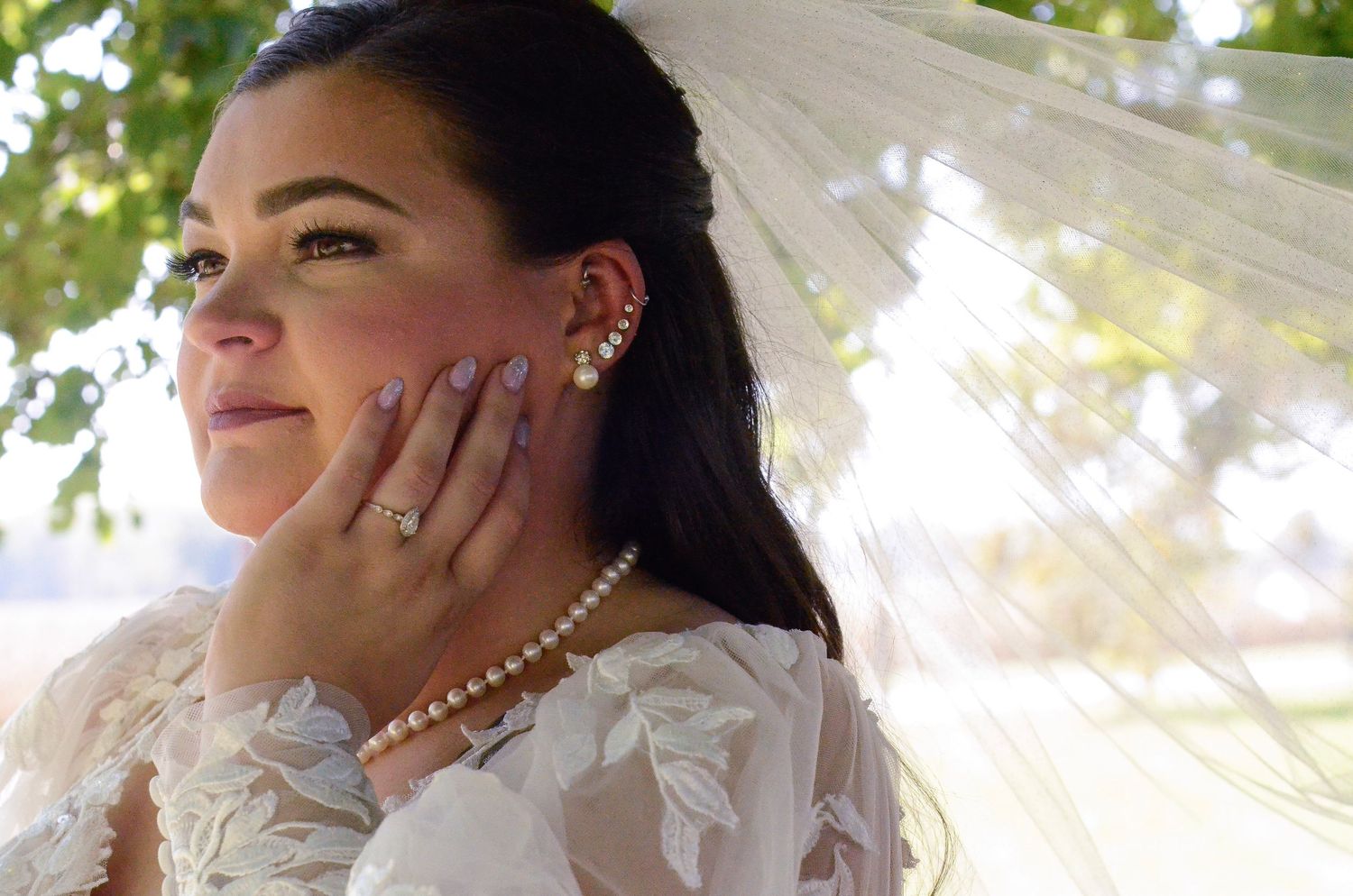 Close-up shot of bride with pearl necklace and flowing veil in natural light. Wedding photos by KM Conceptions Photography in Columbus, OH.