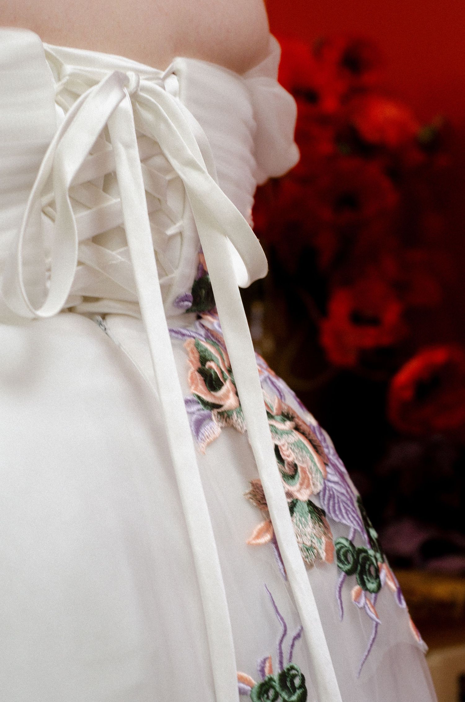 Close-up details of white satin bows and floral embroidery on delicate fabric. Photos by KM Conceptions Photography in Newark, OH.