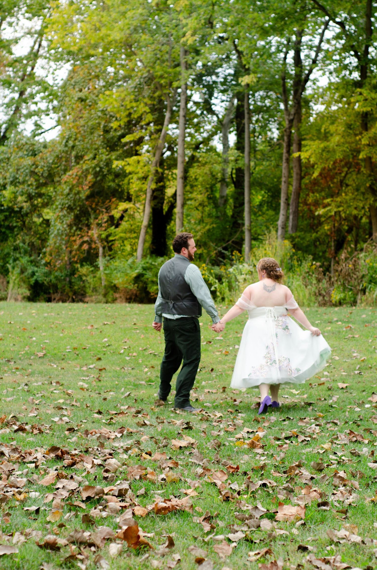 Playful sequence of wedding photos taken on grass covered with autumn leaves. Wedding photos by KM Conceptions Photography in Columbus, OH.