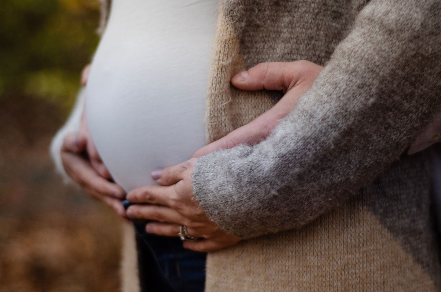 Close-up shots of a pregnant belly being held in a loving embrace.