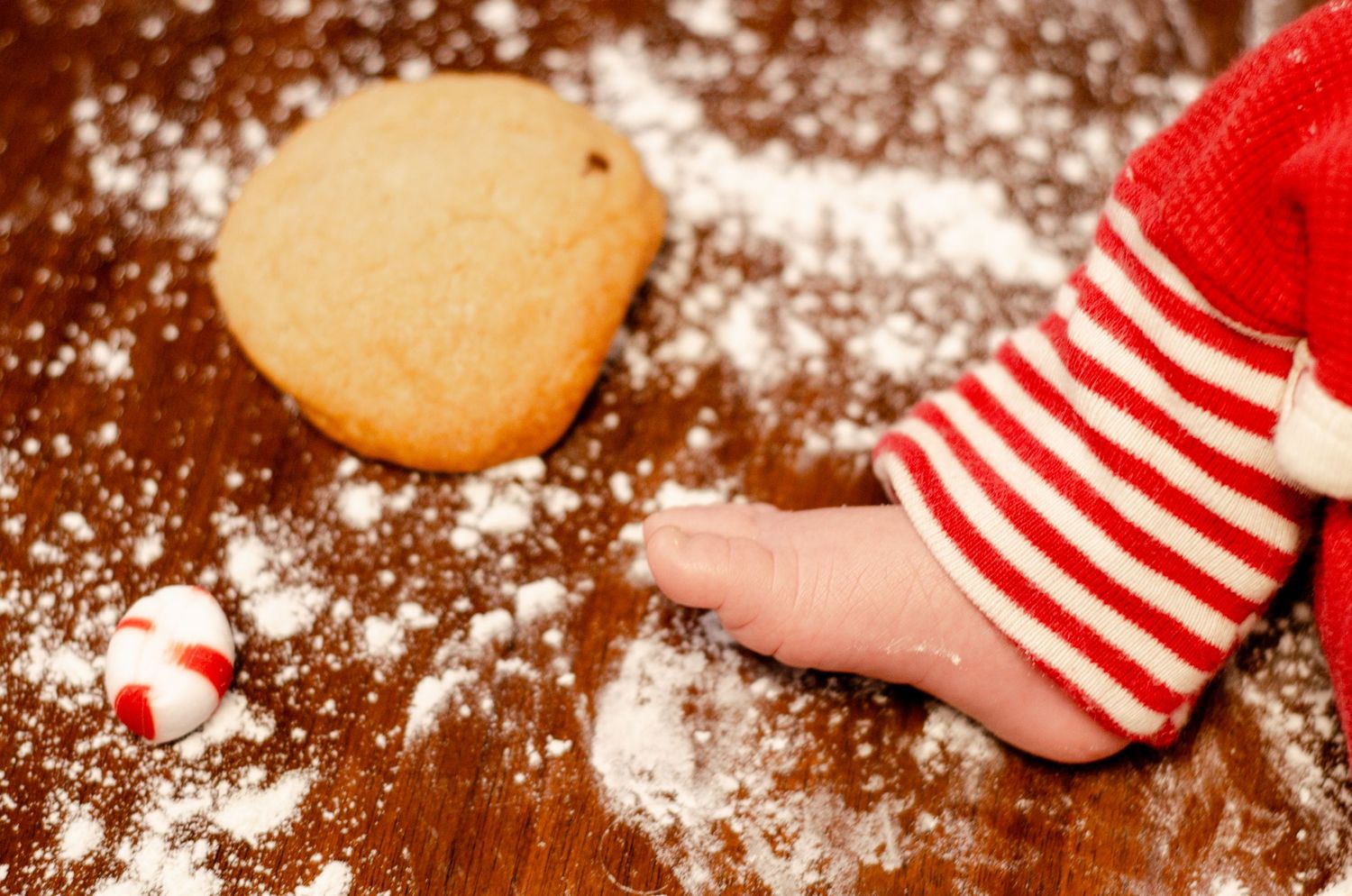Small feet in festive striped pajamas surrounded by flour and holiday baking ingredients. Newborn photography in Columbus, OH