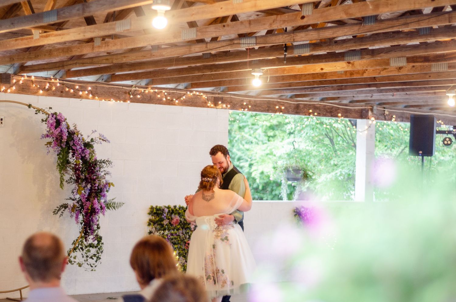 Rustic wedding venue interior with exposed wooden beams and string lights. Wedding photos by KM Conceptions Photography in Columbus, OH.