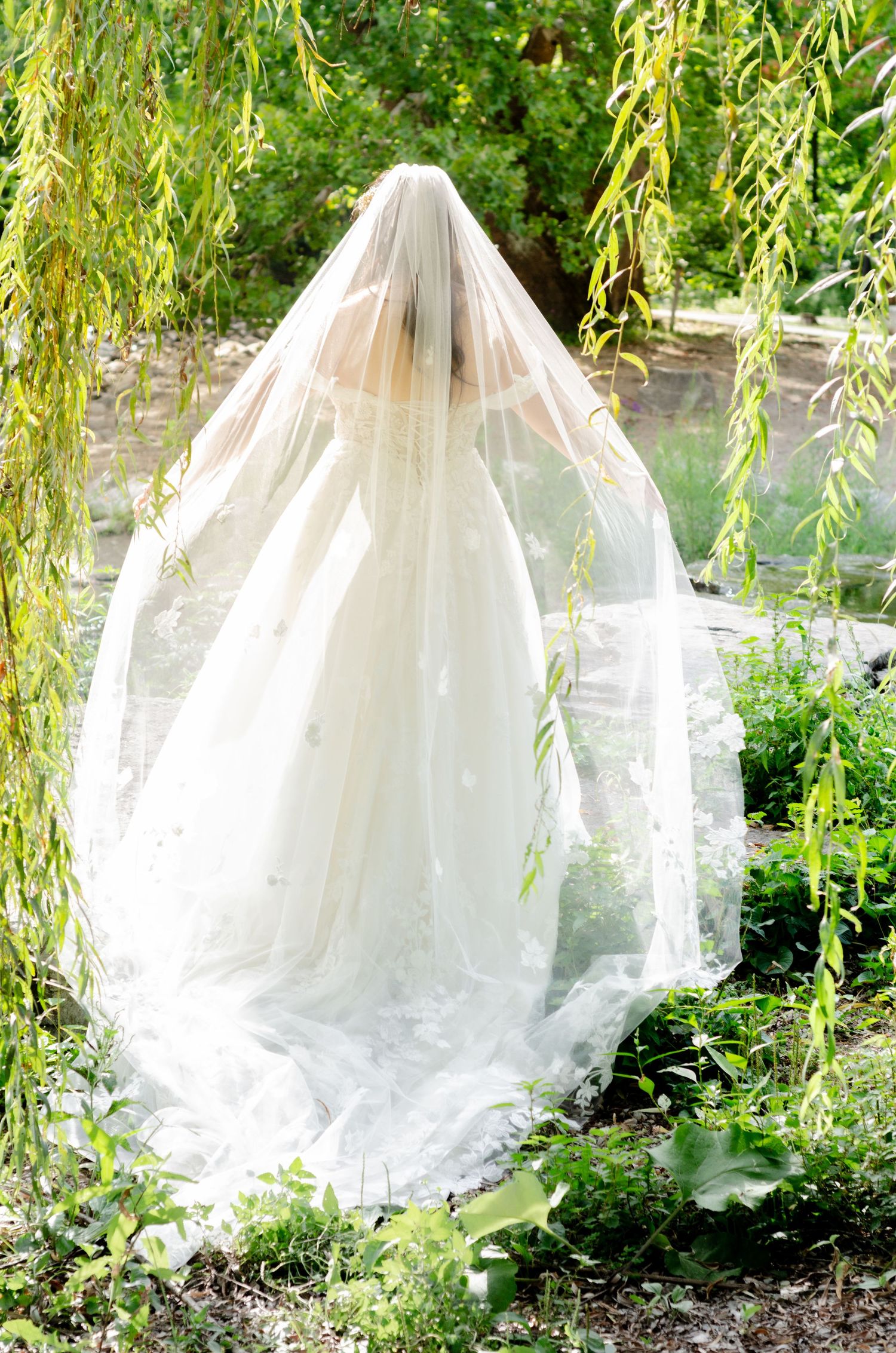 Flowing white wedding dress train photographed under cascading willow. Wedding photos by KM Conceptions Photography in Columbus, OH.