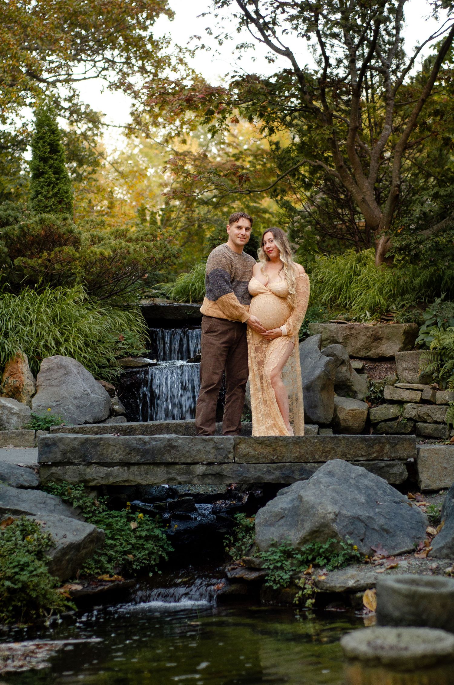 Romantic photoshoot by a waterfall with stone steps and autumn trees. Maternity photos by KM Conceptions Photography in Columbus, OH.