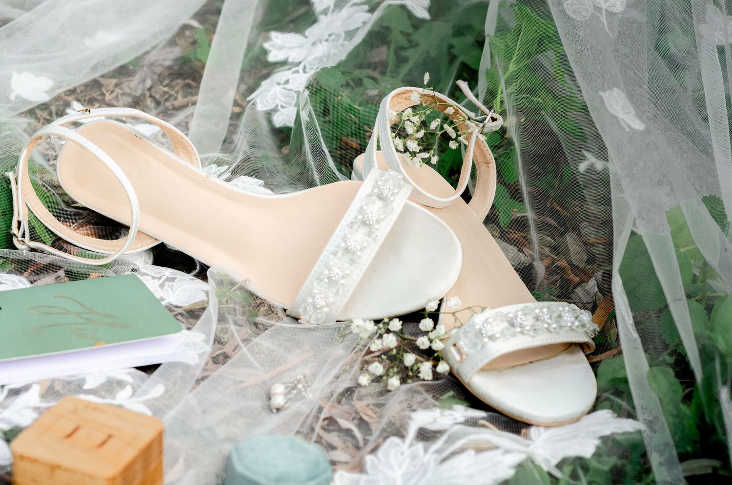 Wedding accessories including nude heels and jewelry arranged on white fabric. Wedding photos by KM Conceptions Photography in Columbus, OH.