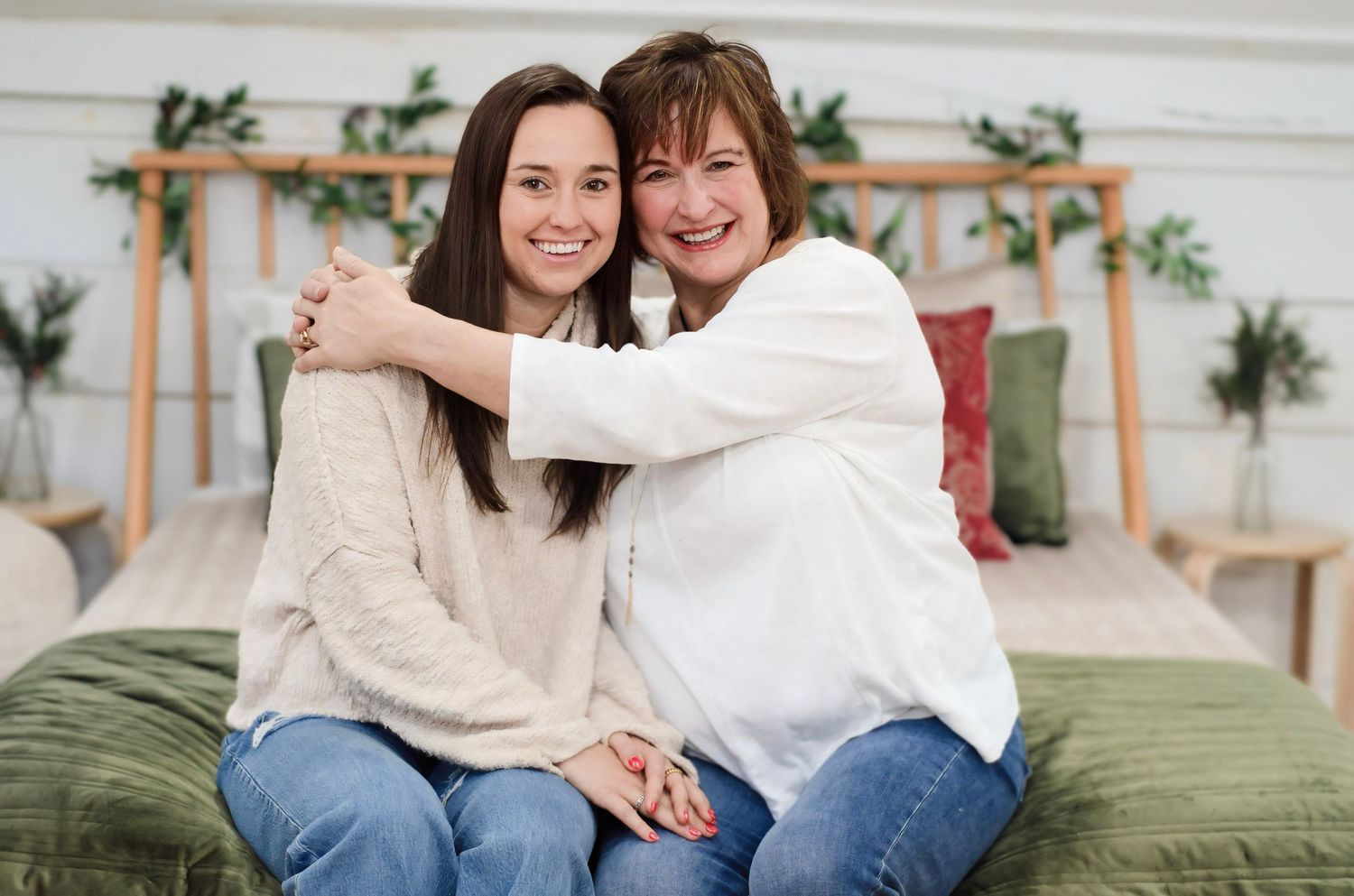 Group poses together on comfortable indoor furniture with decorative backdrop.