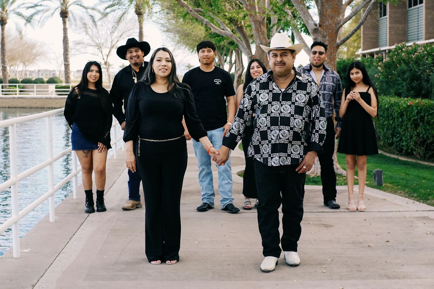 A group of people walking together in a line outdoors on a sunny day.