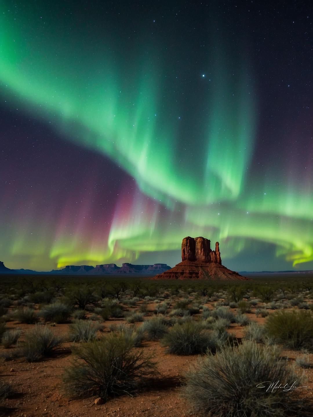 Vibrant green aurora borealis dances above a sandstone butte in Monument Valley against a starry desert night sky.