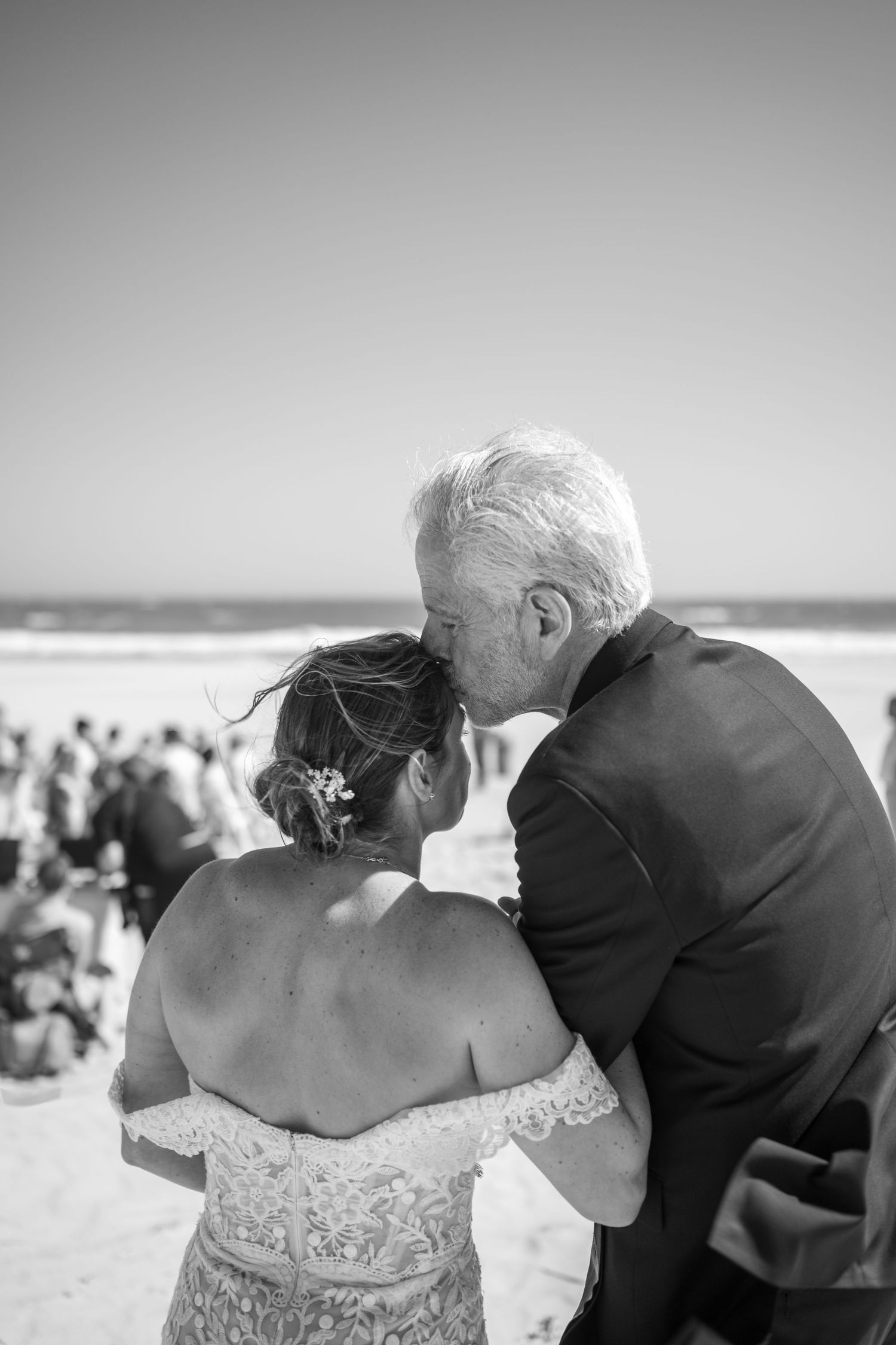 A romantic sequence of black and white photos showing a couple sharing tender moments on a beach.
