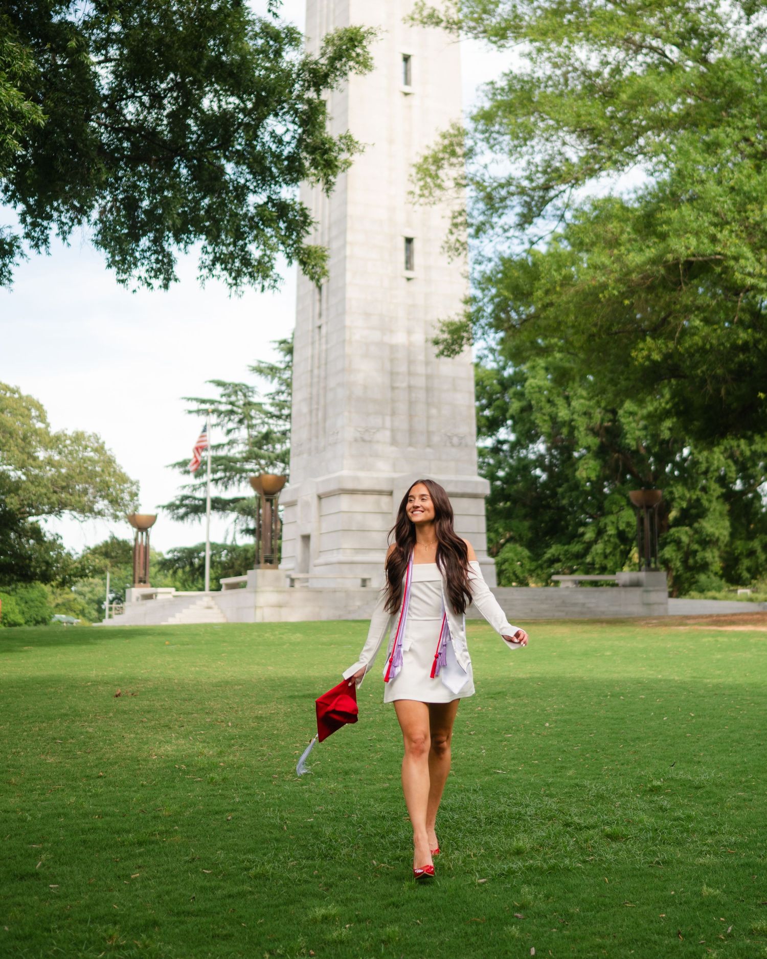 A series of four photos showing someone in white attire walking on a grassy lawn near a tall concrete structure.