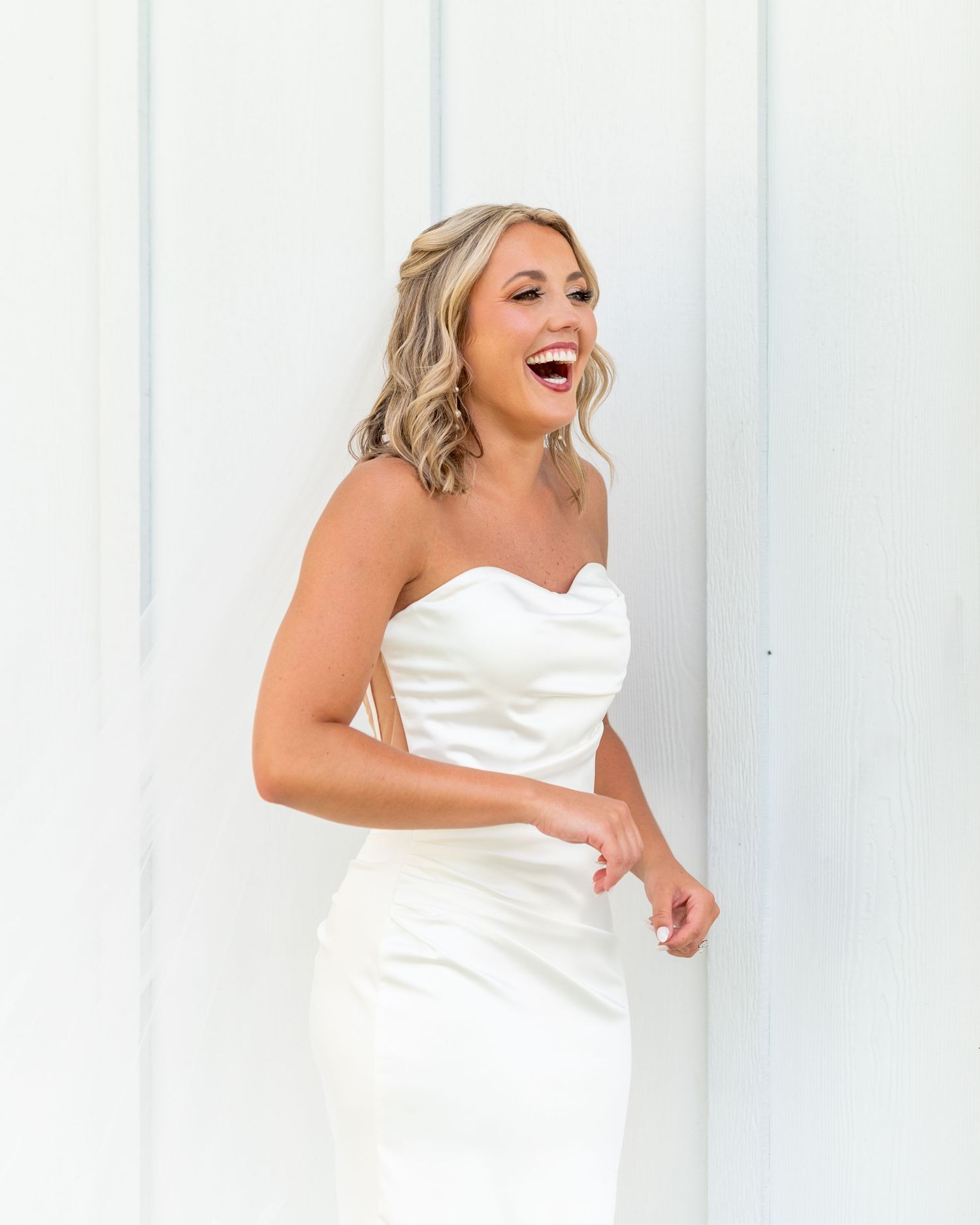 A person in a white strapless dress poses playfully in a sequence of four candid shots against a white backdrop.