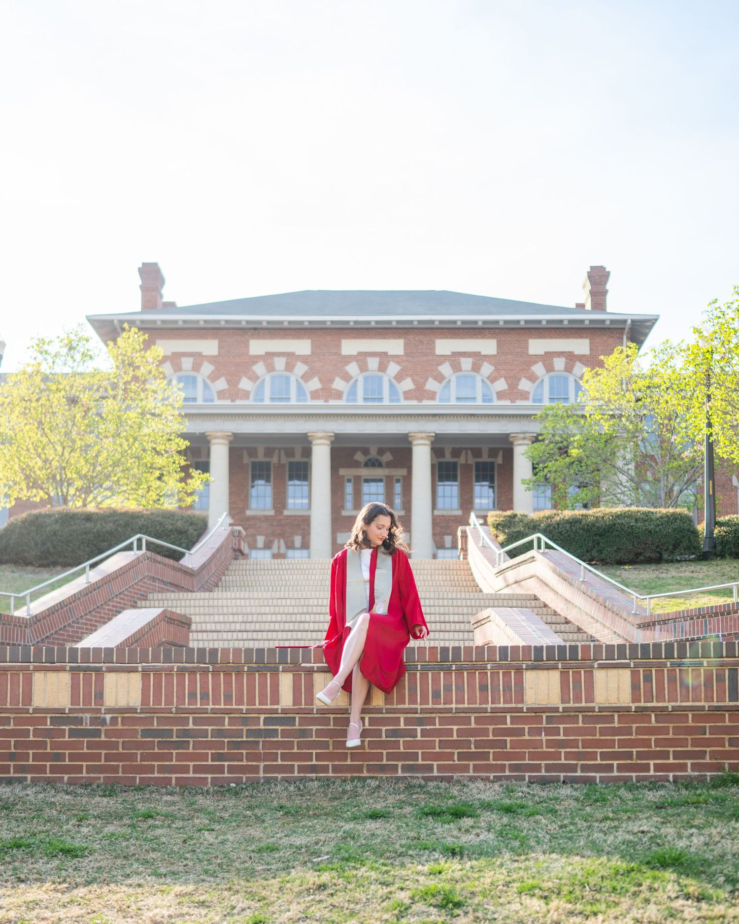 A sequence of four photos showing someone doing a cartwheel on a brick wall in front of a traditional brick building.