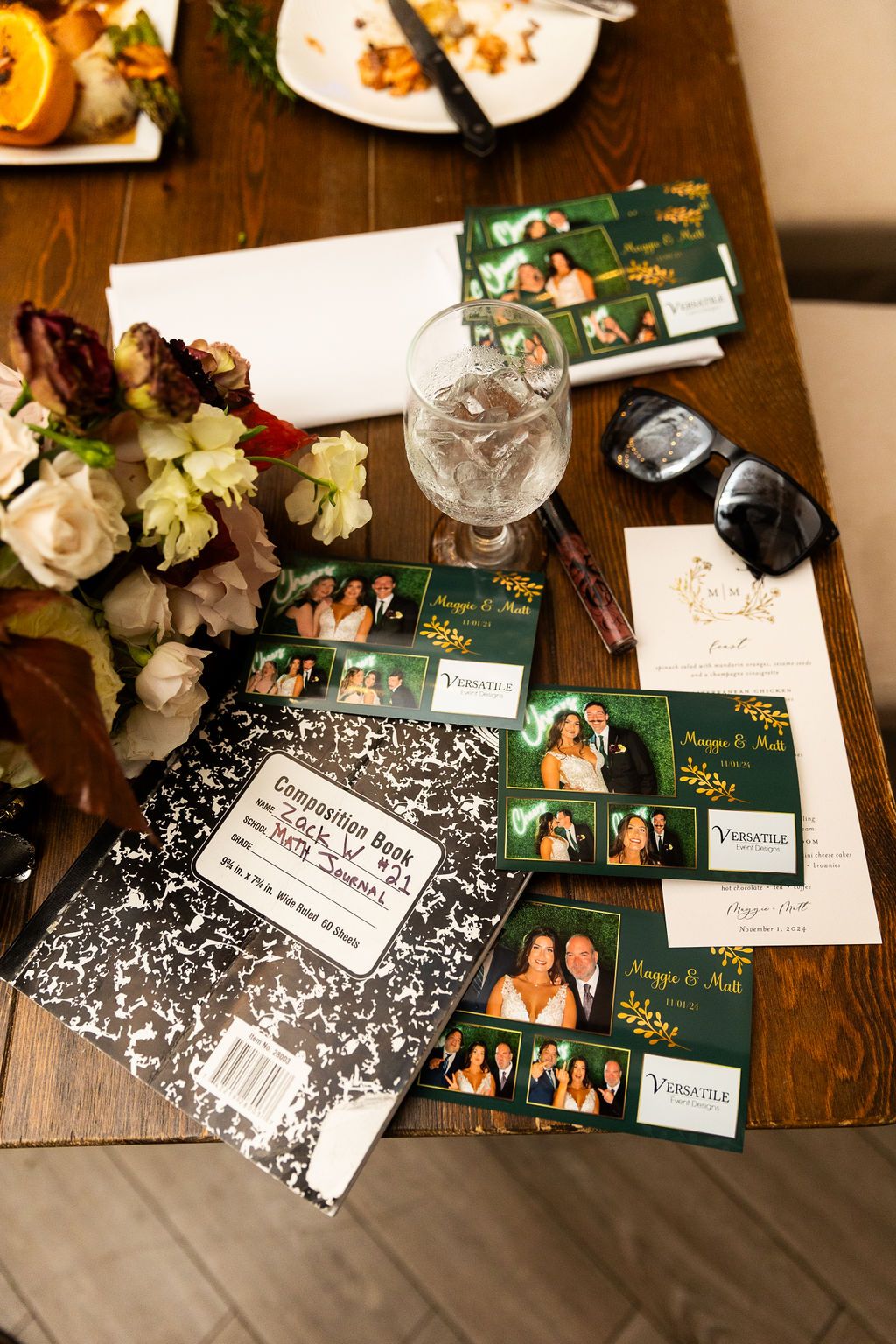 Photo booth prints and guest book spread on wooden table at Maggie and Matt wedding.