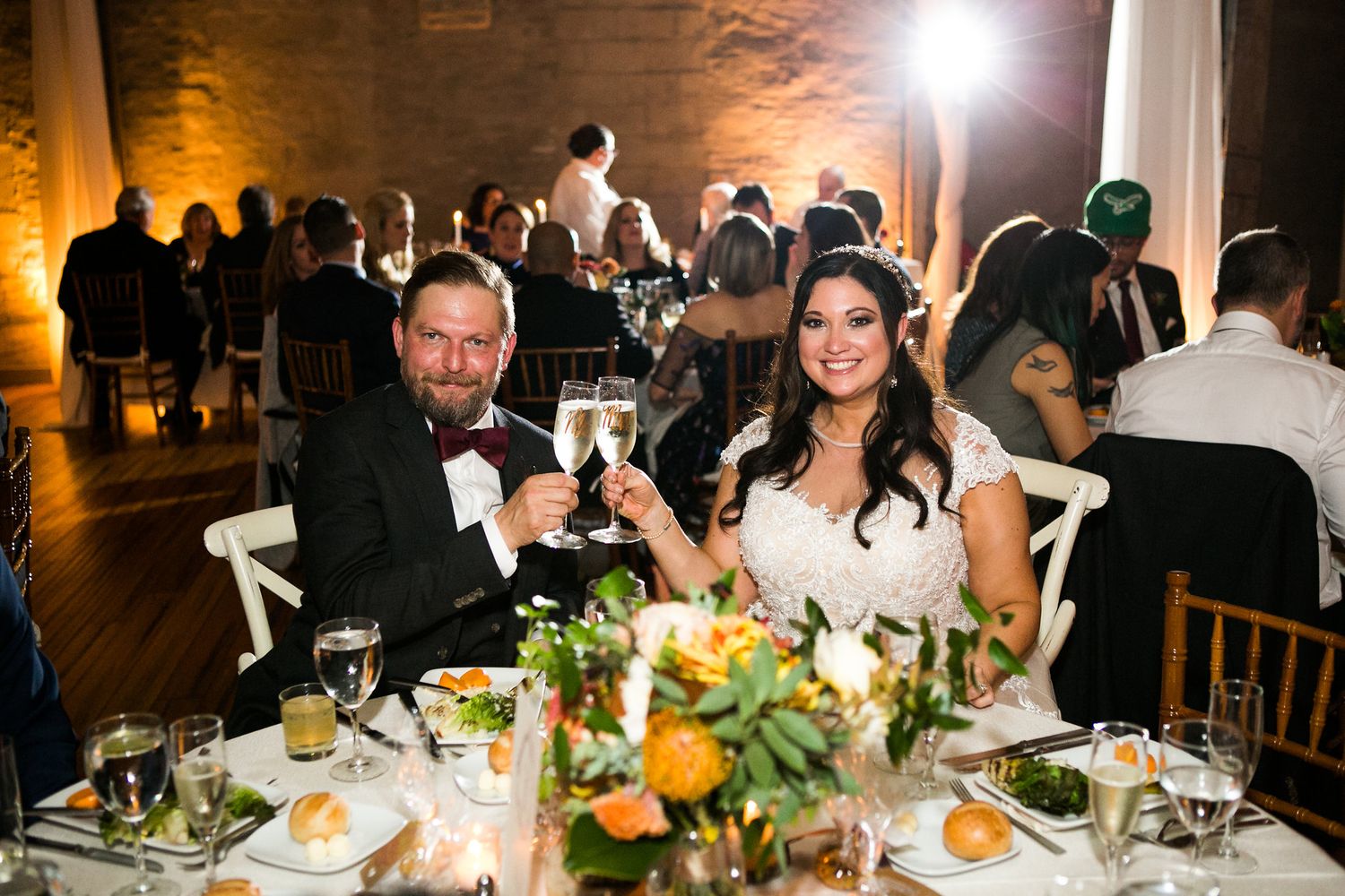 Bride and groom toasting champagne at wedding reception dinner.
