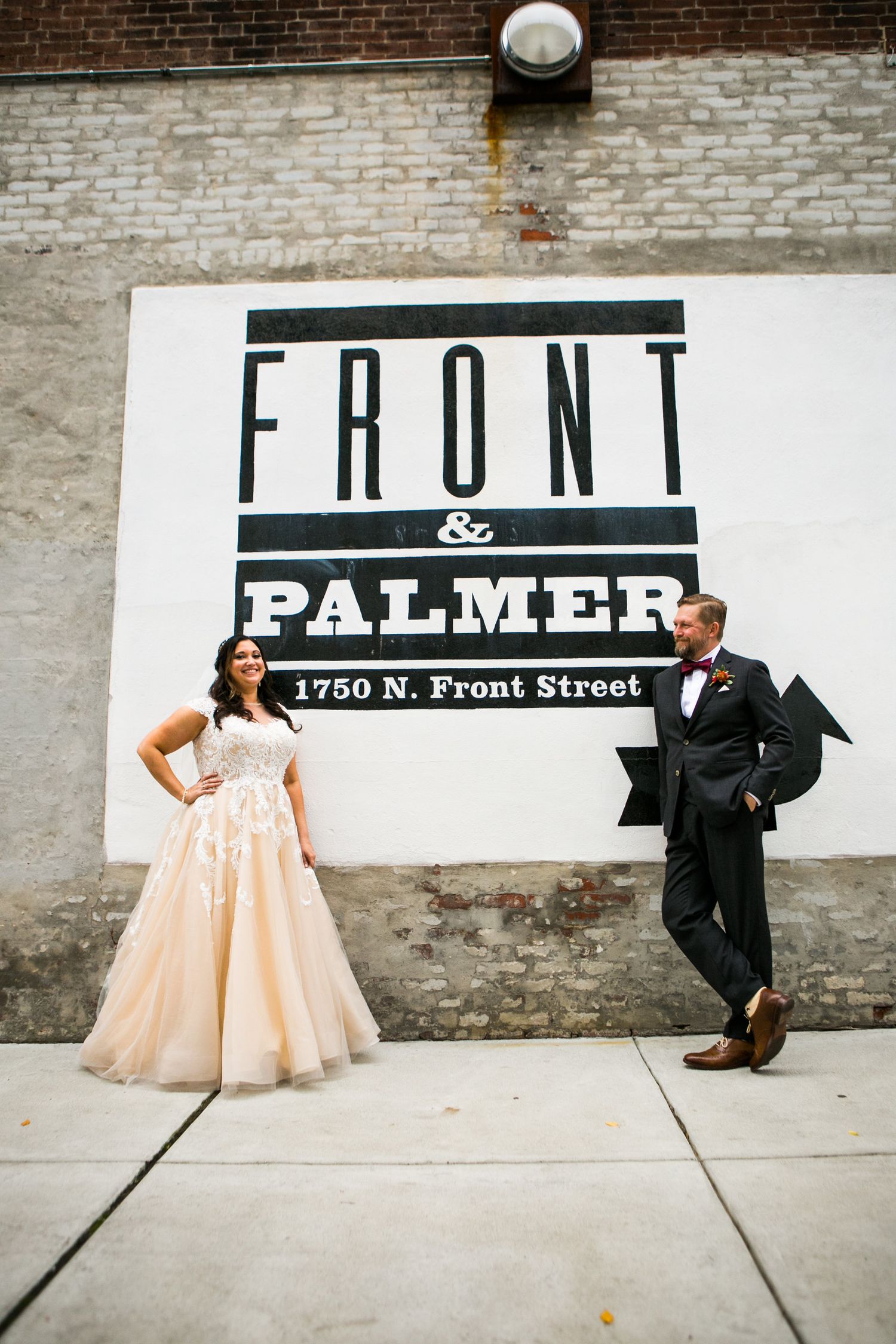 Bride and groom pose in front of the Front and Palmer 1750 N. Front Street wedding venue sign.