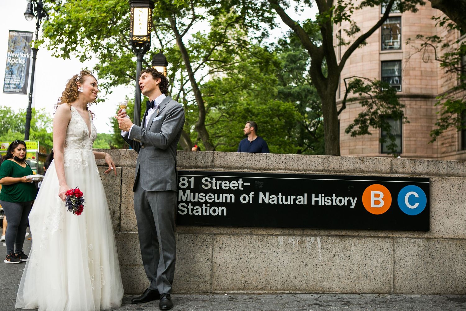 Bride and groom sharing ice cream outside the 81st Street Museum of Natural History subway station in NYC.