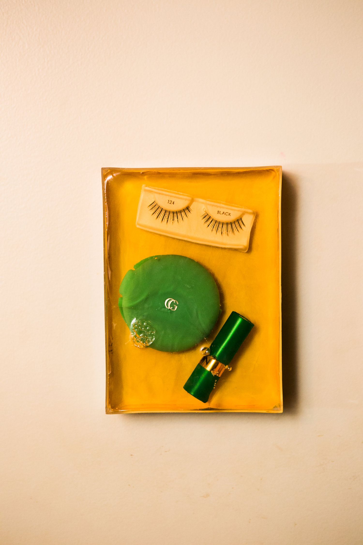 Wedding day touch-up kit with green Gucci compact, lipstick, and false eyelashes in a yellow box.
