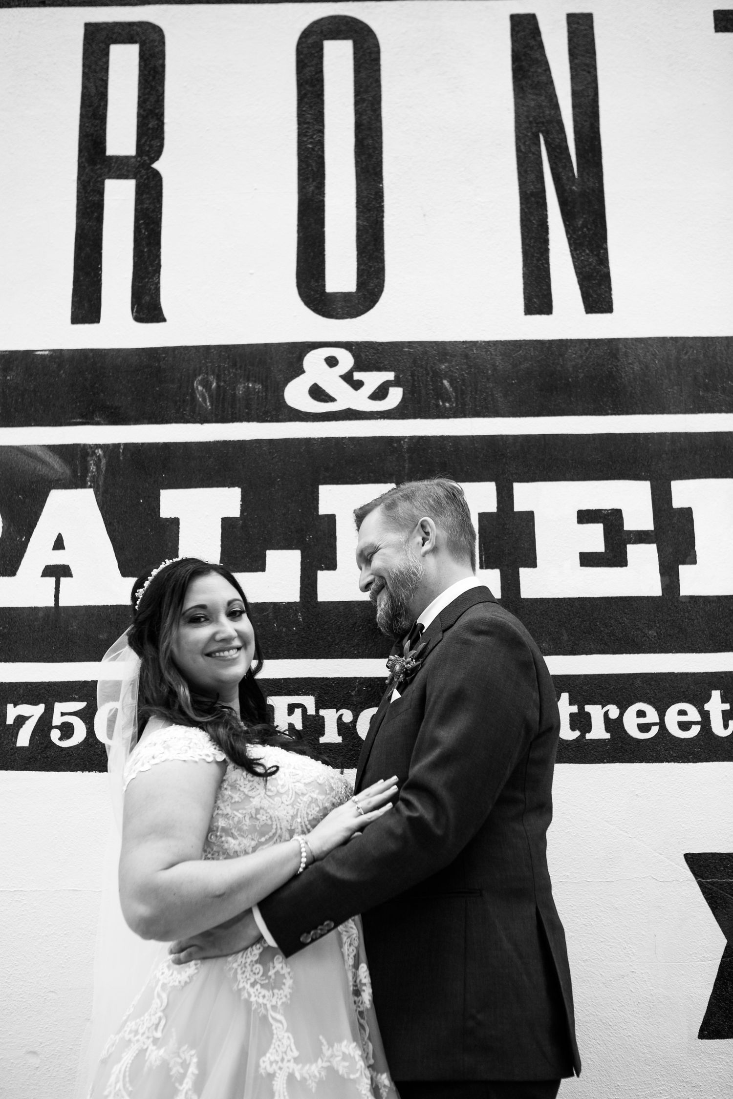 Bride and groom share a romantic moment in black and white photo outside Front and Palmer venue.