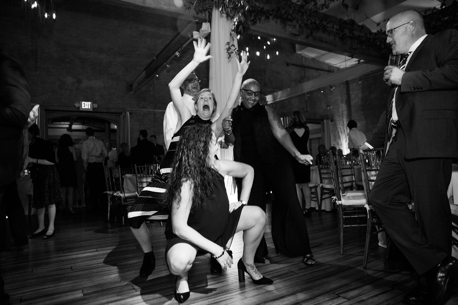 Guests dancing energetically on the dance floor at a lively wedding reception.