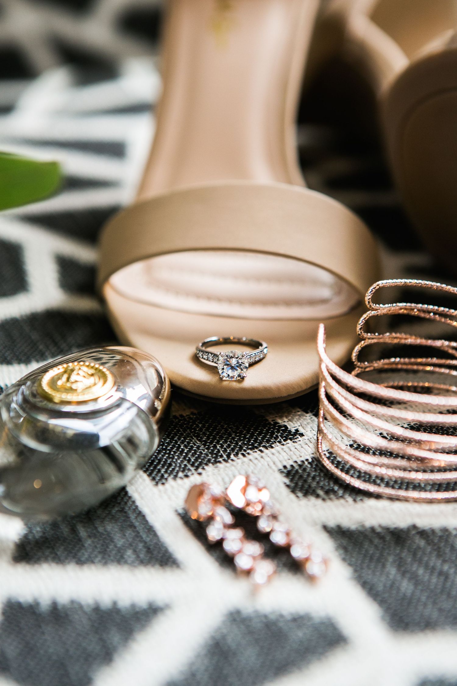 Bridal accessories flat lay with diamond engagement ring, rose gold bracelets and nude heels.