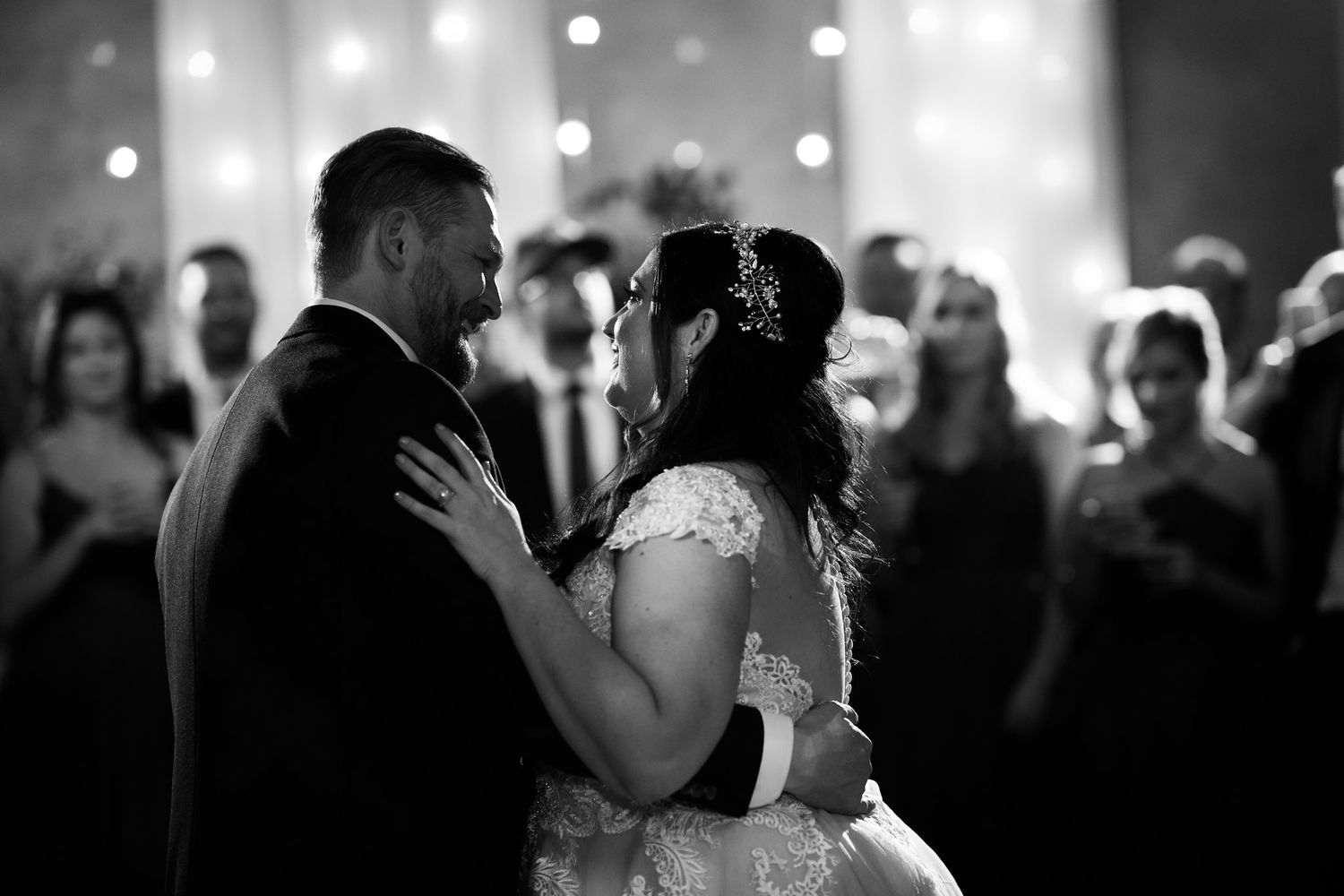 Black and white photo of bride and groom sharing intimate first dance at wedding.