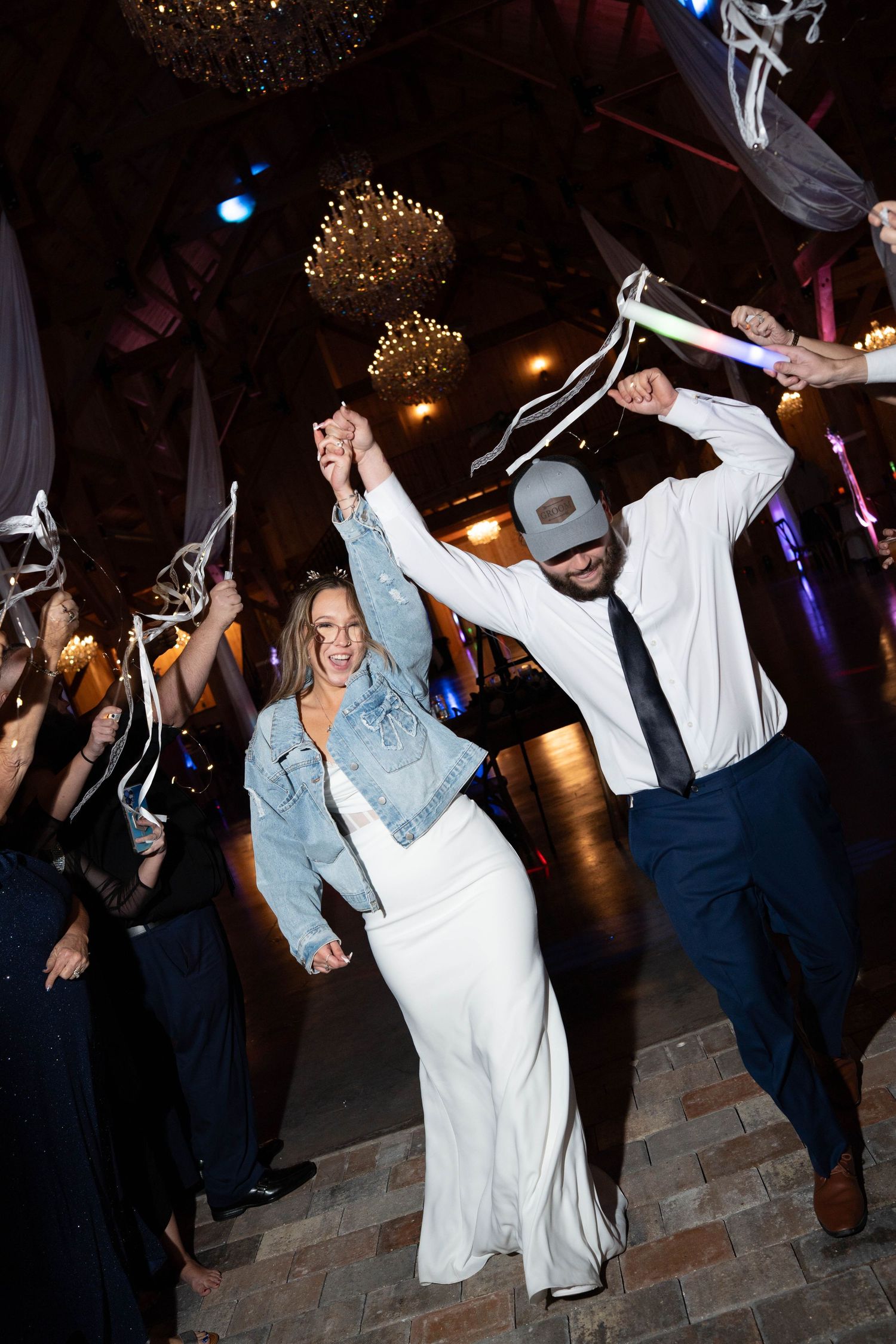 Bride and groom celebrate joyful grand exit surrounded by cheering wedding guests.