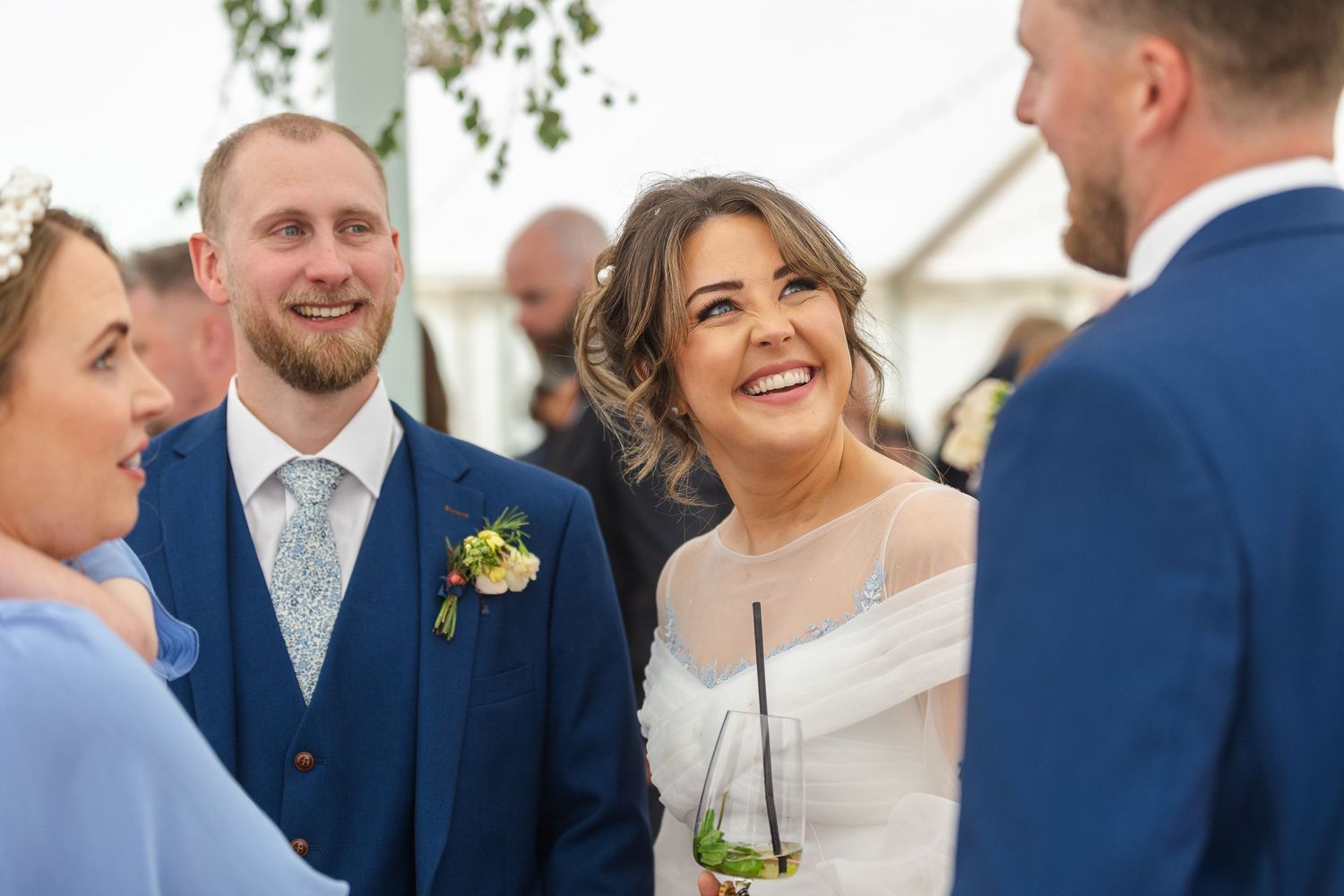 candid photo of bride looking at her groom and the groomsman
