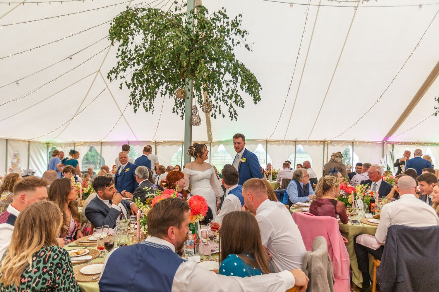 Candid wedding photography Leicestershire - couple laughing with guests during wedding reception