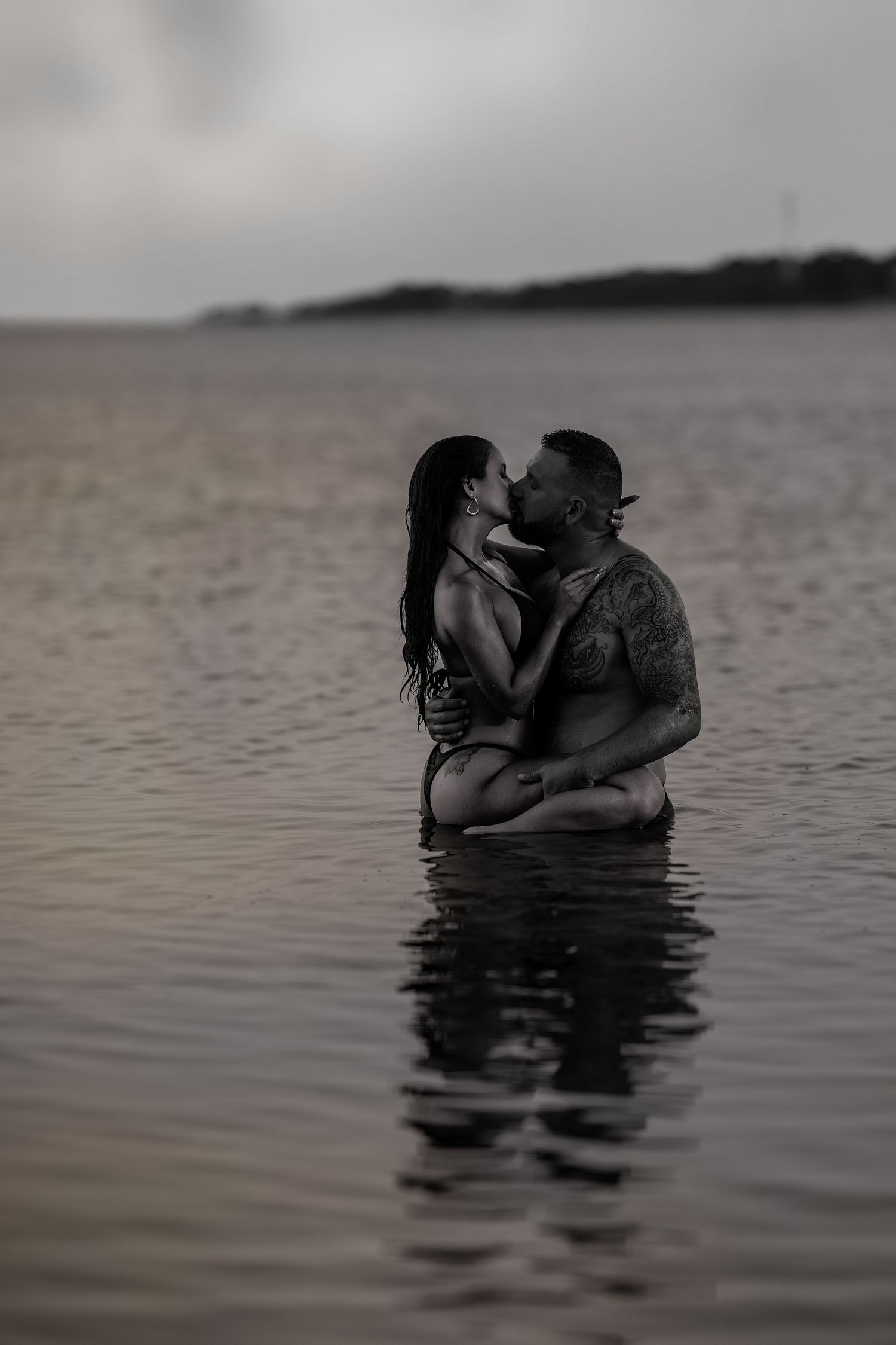 Couple sharing an intimate embrace during a luxury couples boudoir photography session in Orlando, Florida.