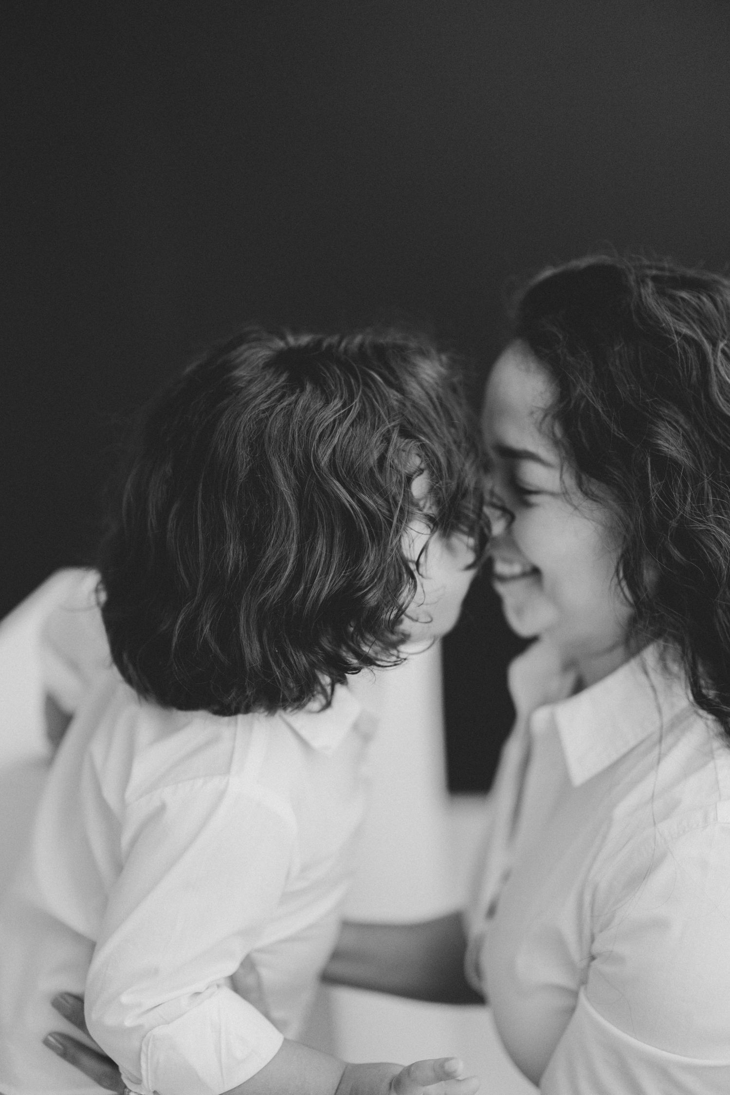 Black and white portrait of curly-haired mother and child sharing a tender nose-to-nose moment. Lafayette indiana tippecanoe county west laf