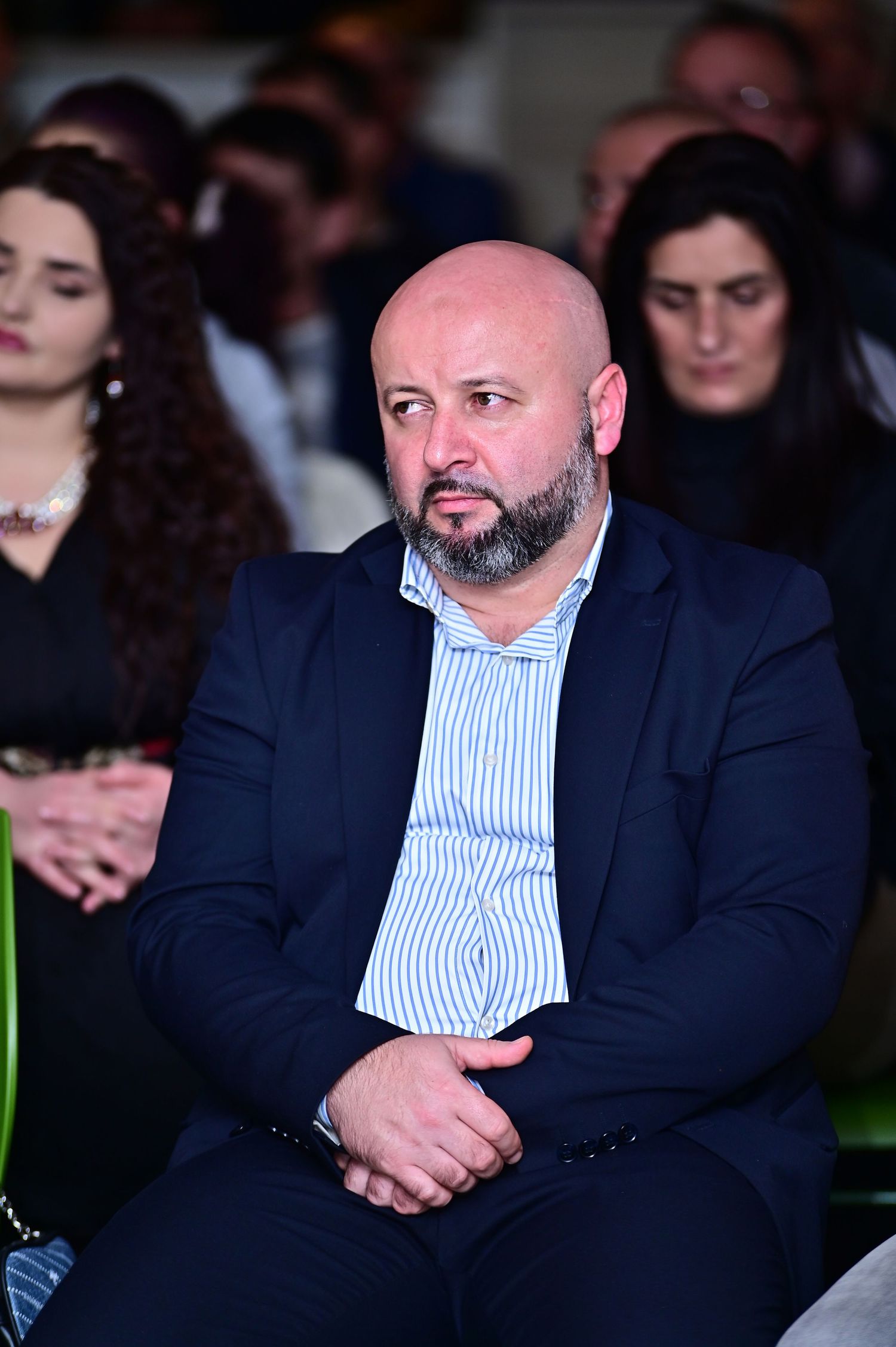 Professional woman in a white blazer attending a business conference, corporate event, or leadership seminar, listening attentively