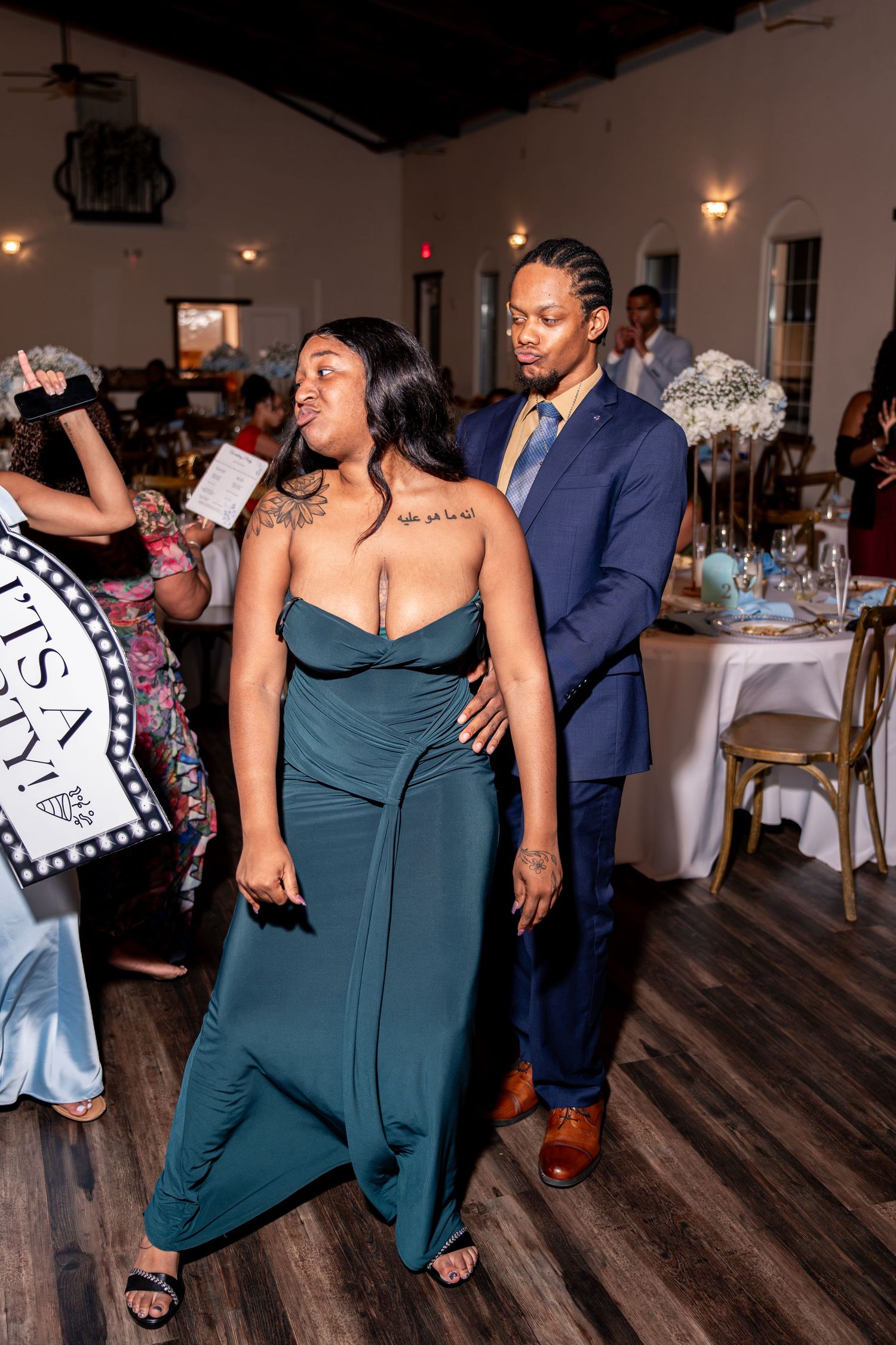 Guests dancing and celebrating at lively indoor wedding reception.