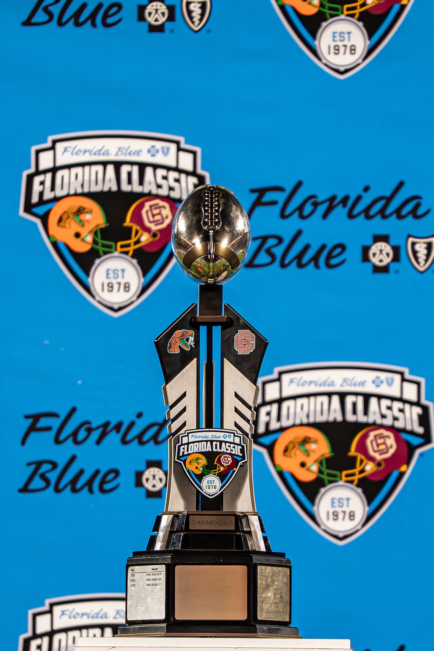Florida Blue Florida Classic football trophy on display with colorful branded backdrop.