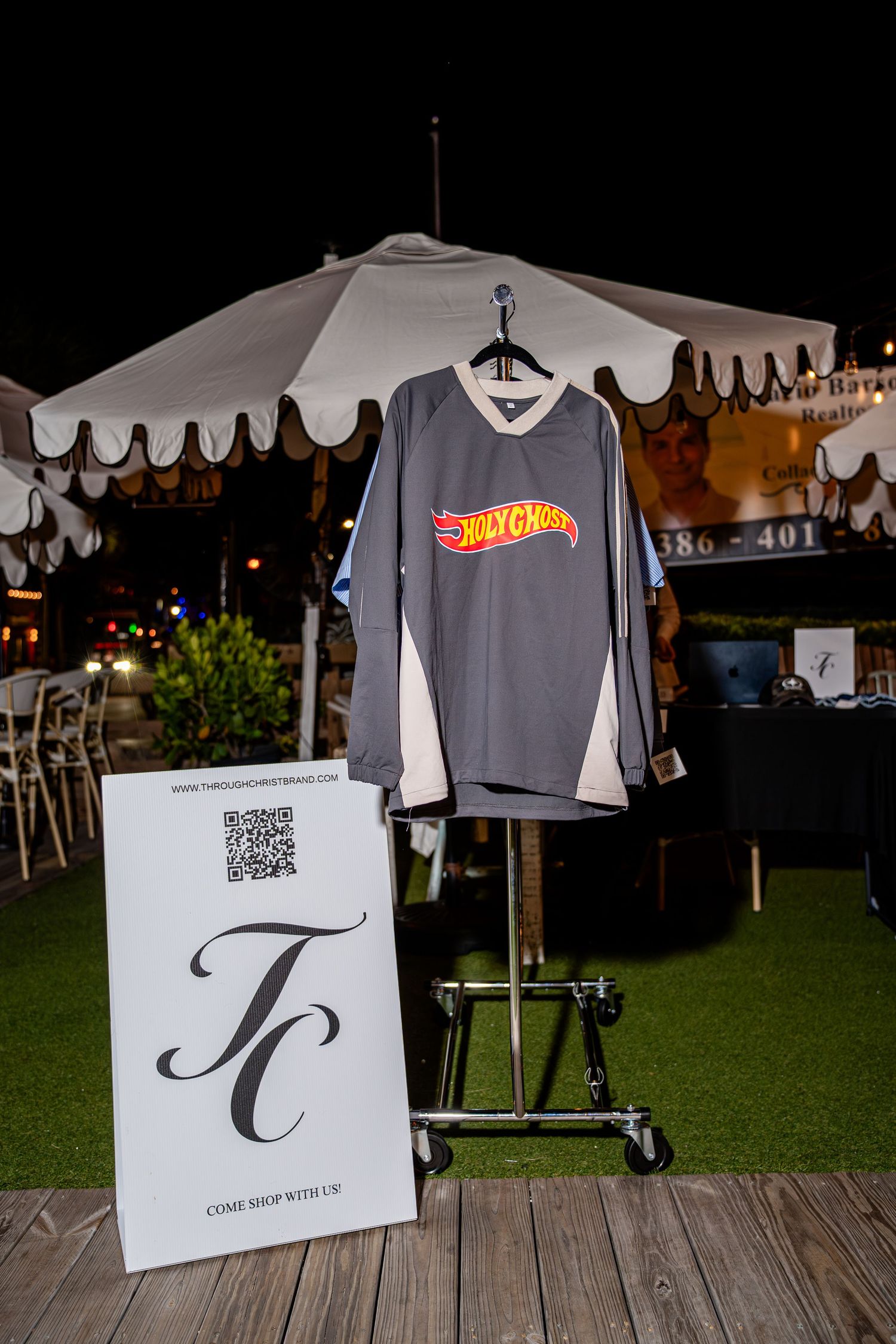 Hot Wheels branded jersey displayed on rack at Through Christ Brand outdoor pop-up shop.