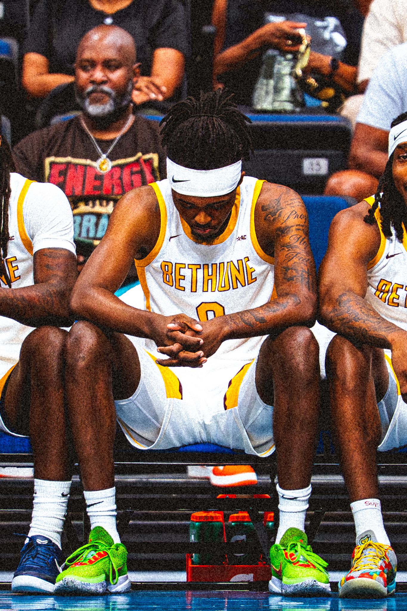 Bethune-Cookman player #0 sits on the bench with teammates during a college basketball game.