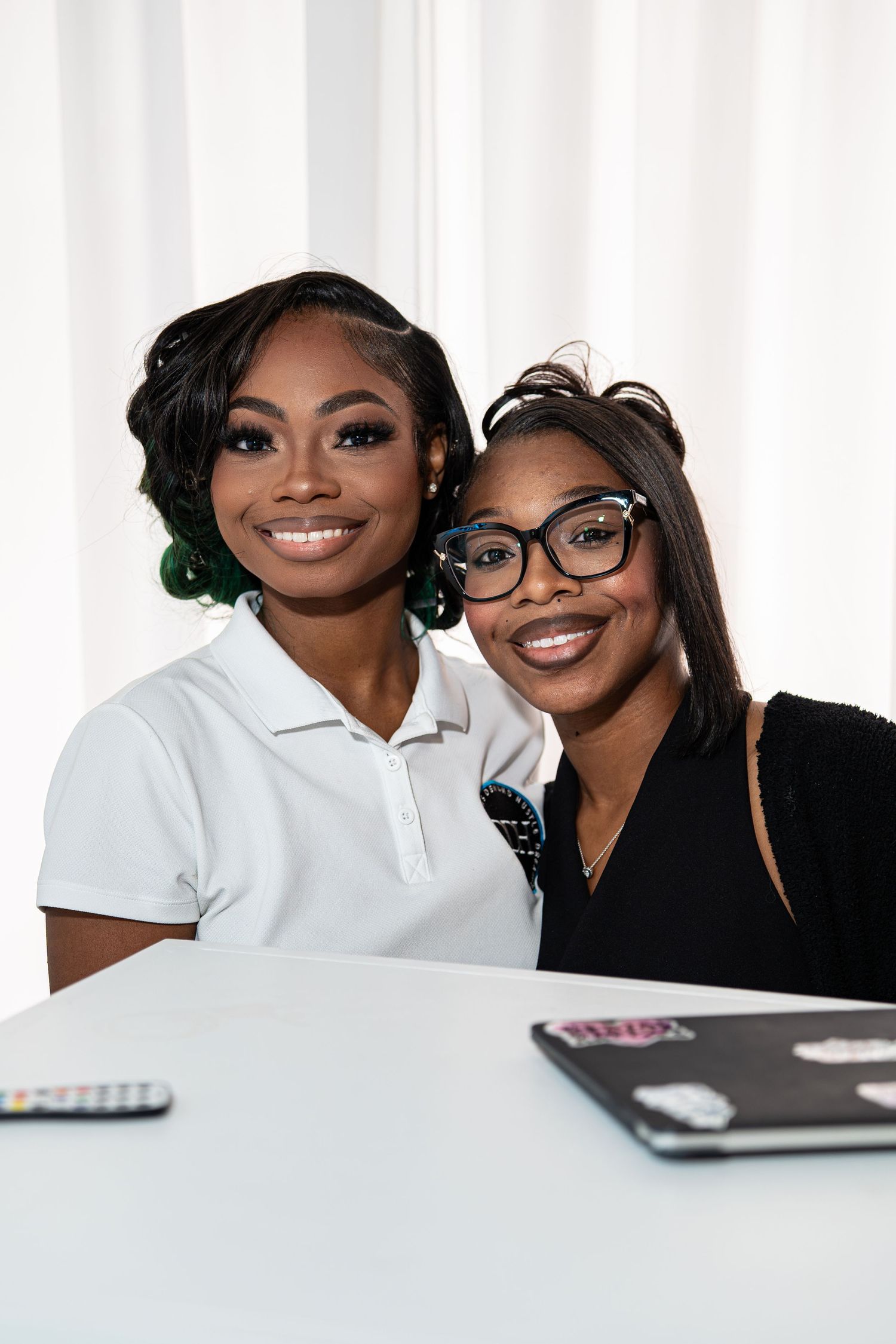 Two smiling women pose together at a table during the Entrepreneur Success Soiree networking event.